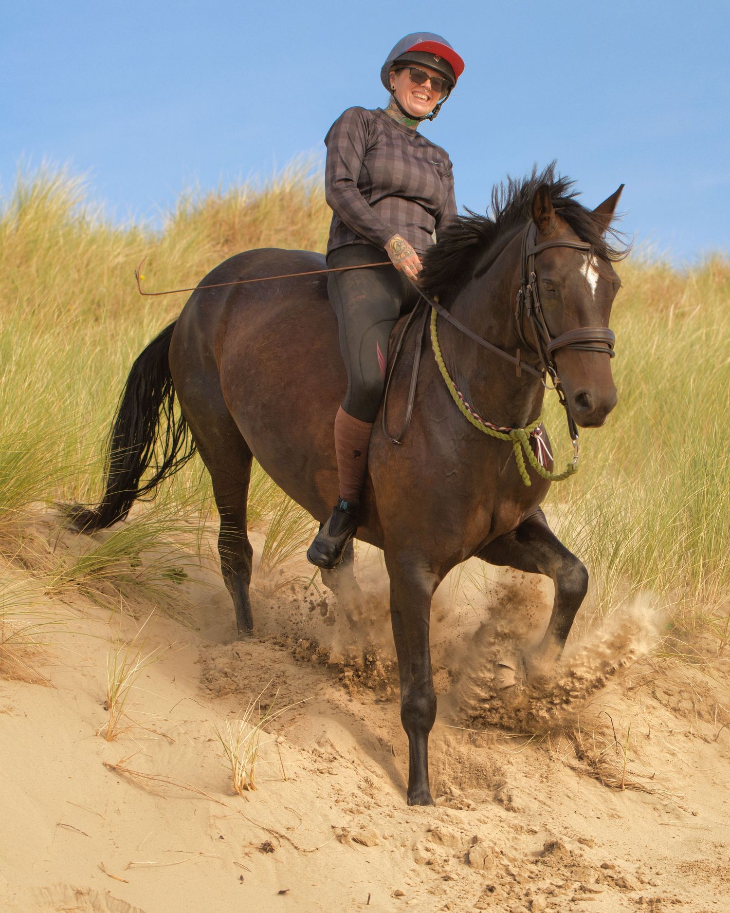 Horse ridden bareback over sandy dunes, rider enjoying the ride with natural movement captured in an outdoor equine photography session