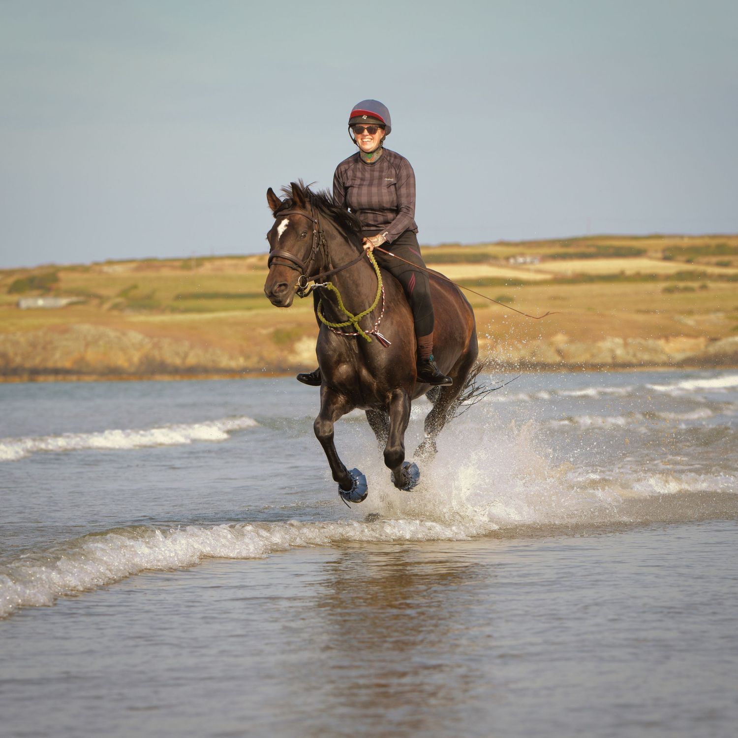 horse racing in the surf with rider happy