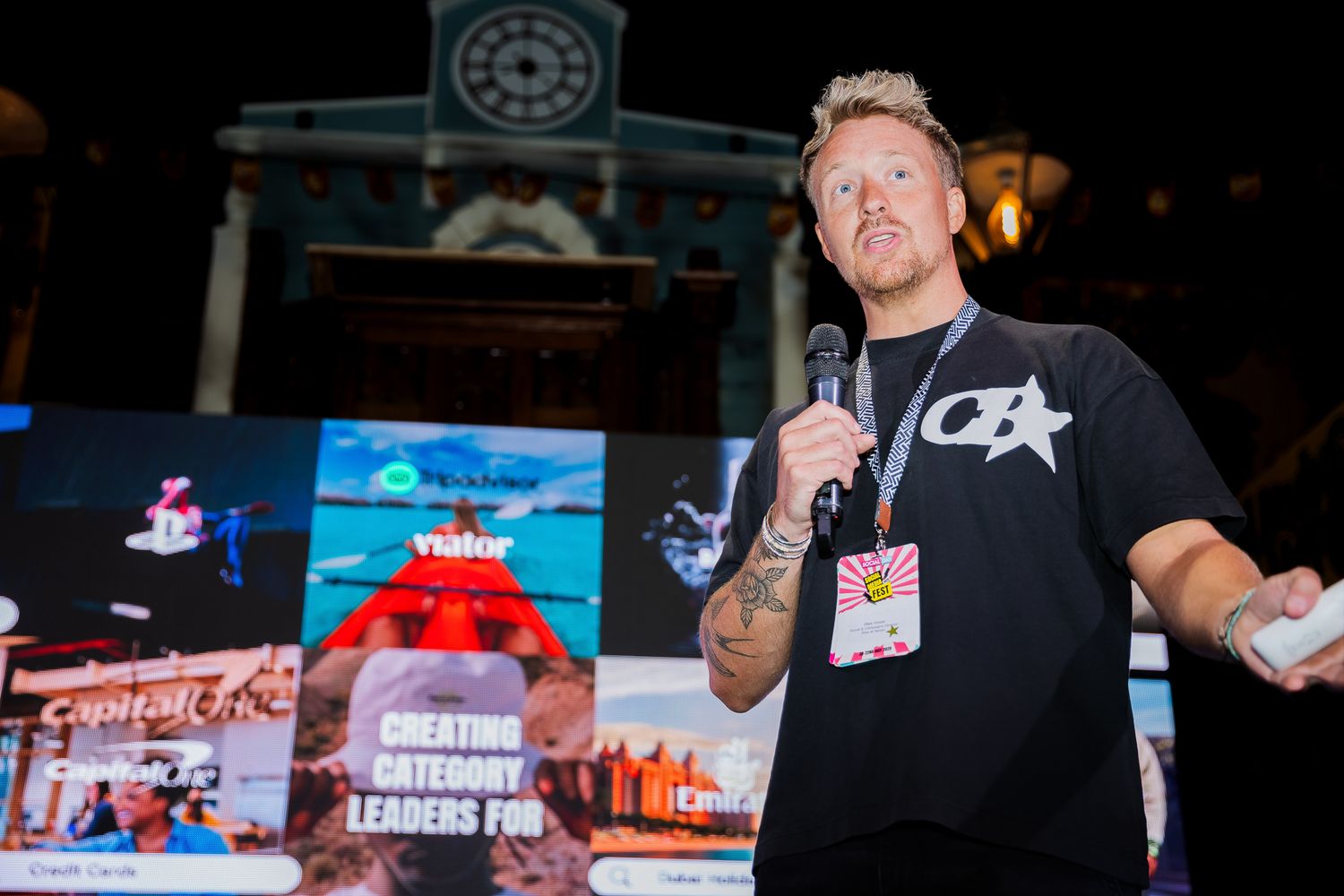 Tattooed male speaker presenting category leaders topic at a startup business conference.