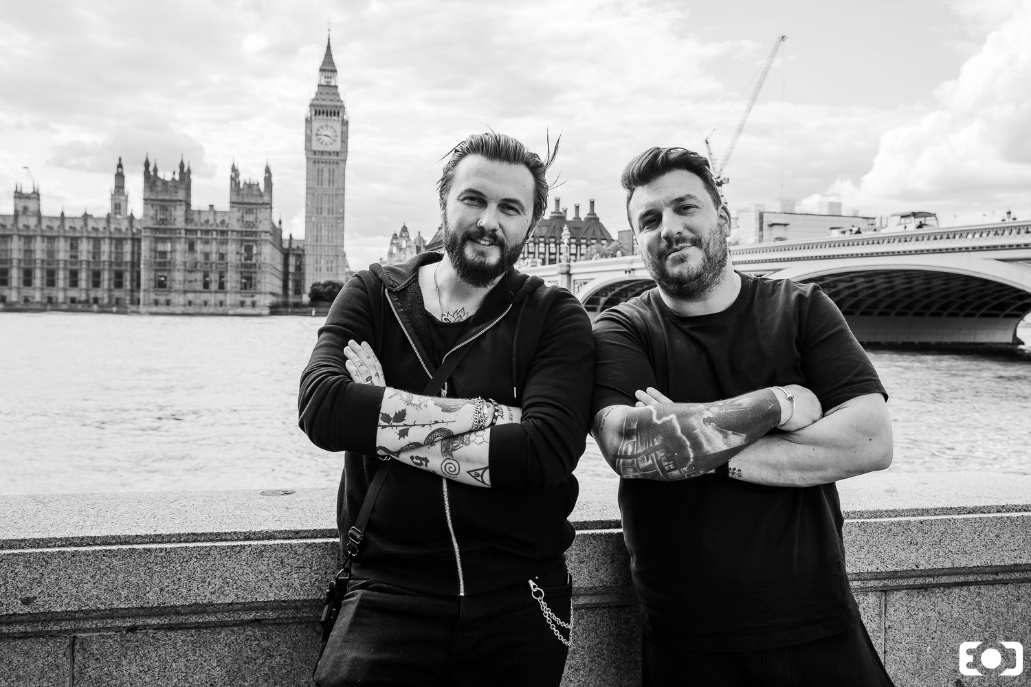 Two tattooed men posing with Big Ben and Westminster Bridge in black and white London photography.
