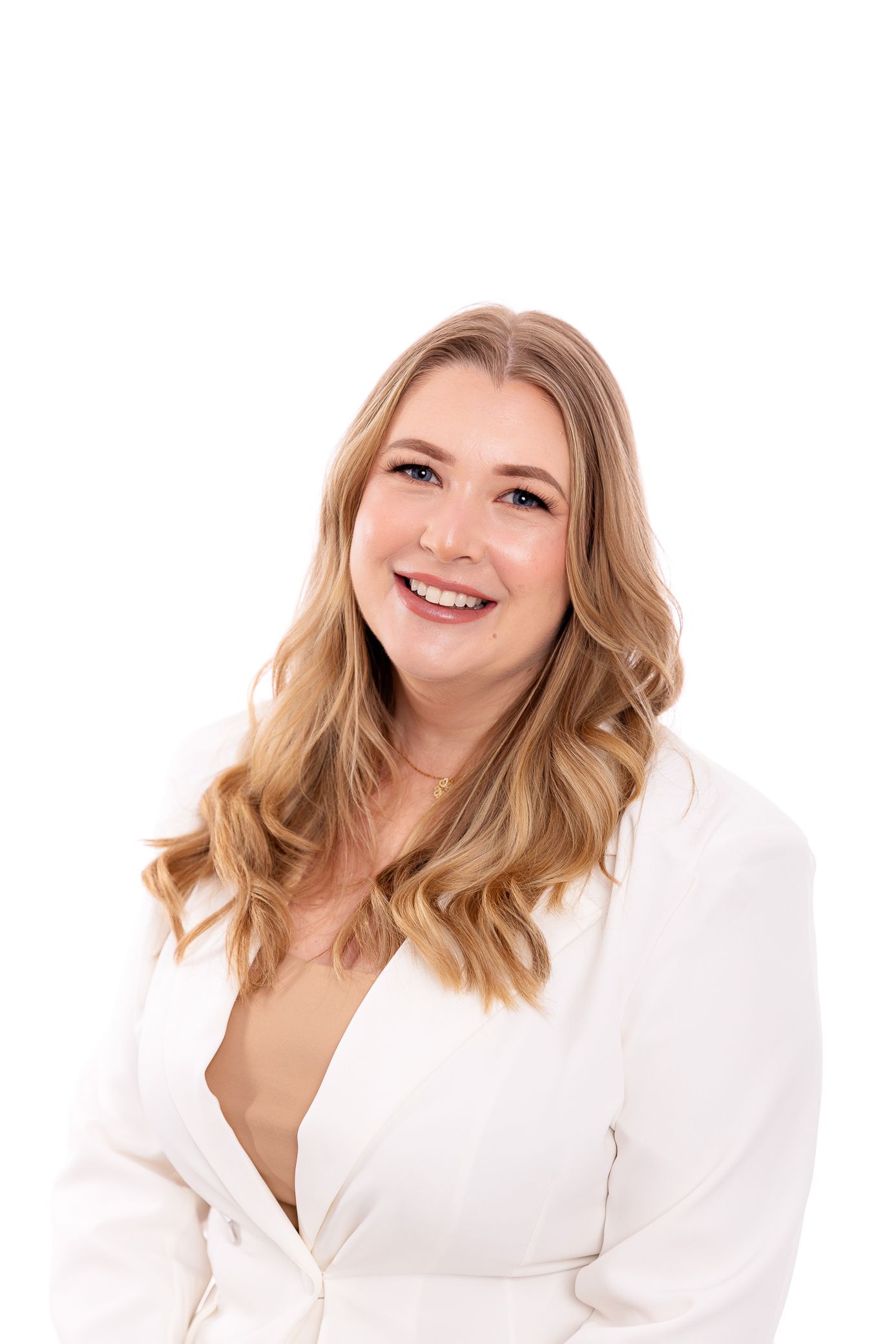 Smiling blonde woman in a white blazer posing against a clean white background.