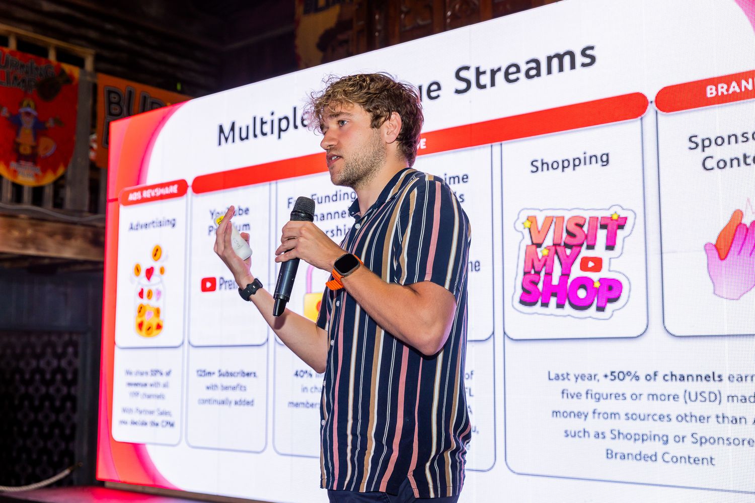 Young man presenting multiple revenue streams slide at a business startup conference.