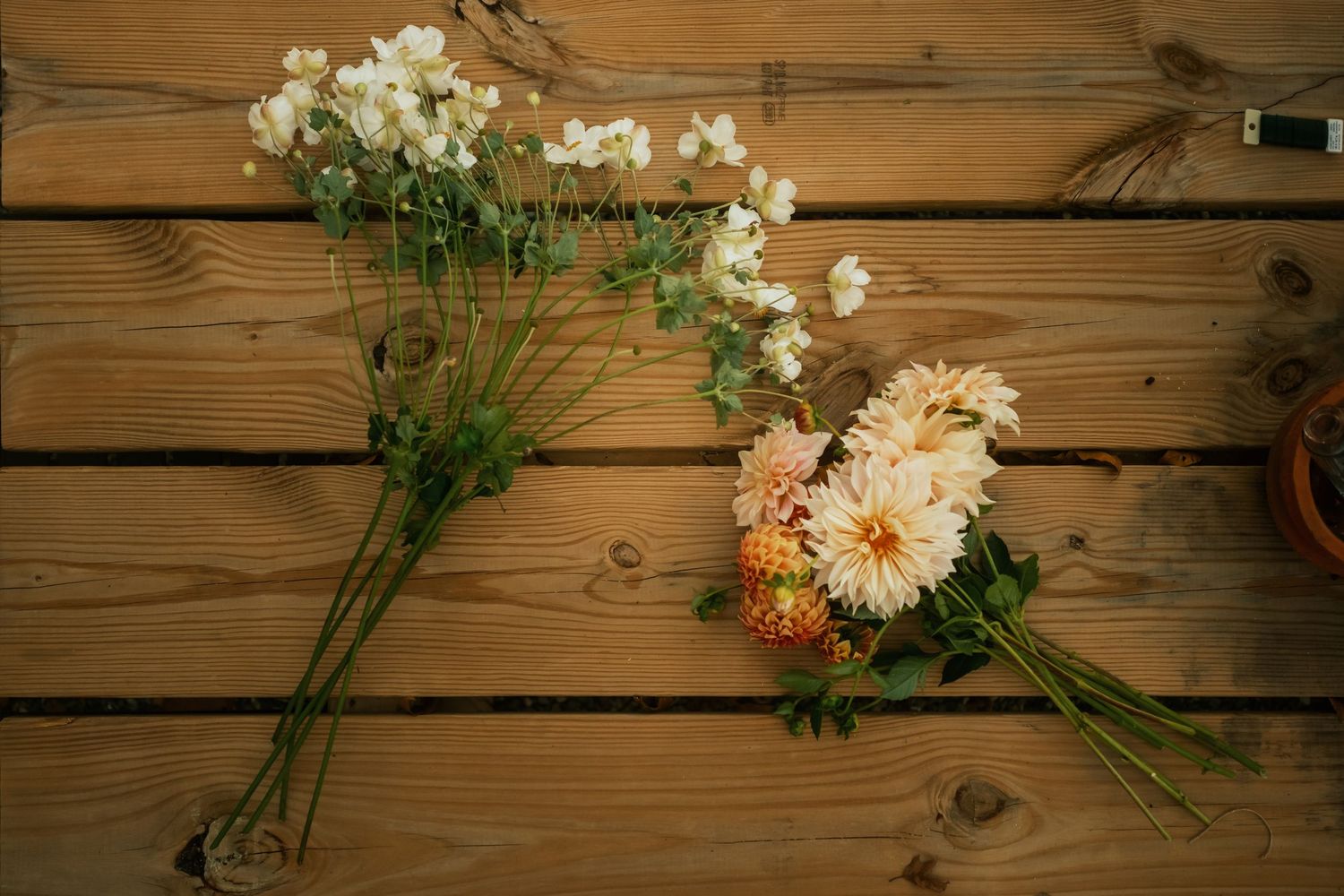 Fresh cut flowers arranged in rustic mason jars against a weathered wooden wall background.