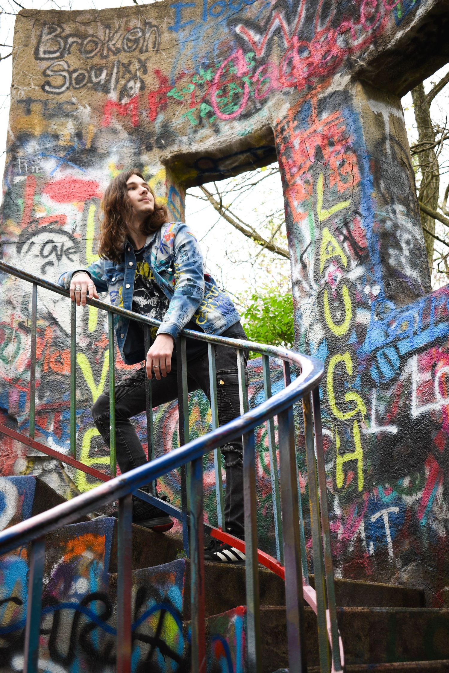 Casual urban fashion shot on graffiti-covered staircase with text 'Broken Soul'.