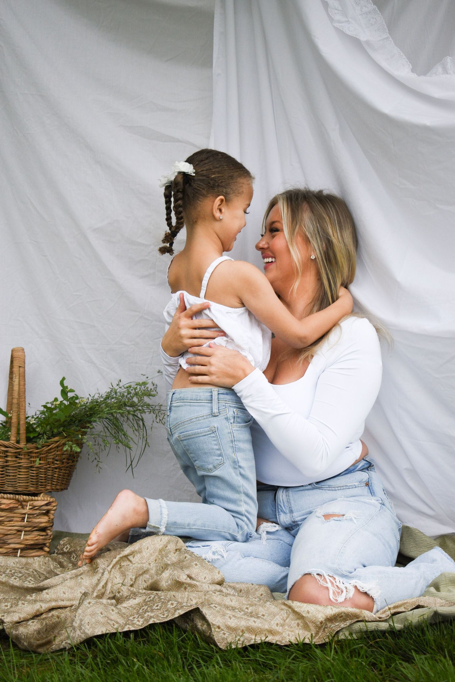 Intimate portrait session on burlap blanket with white backdrop and wicker basket.