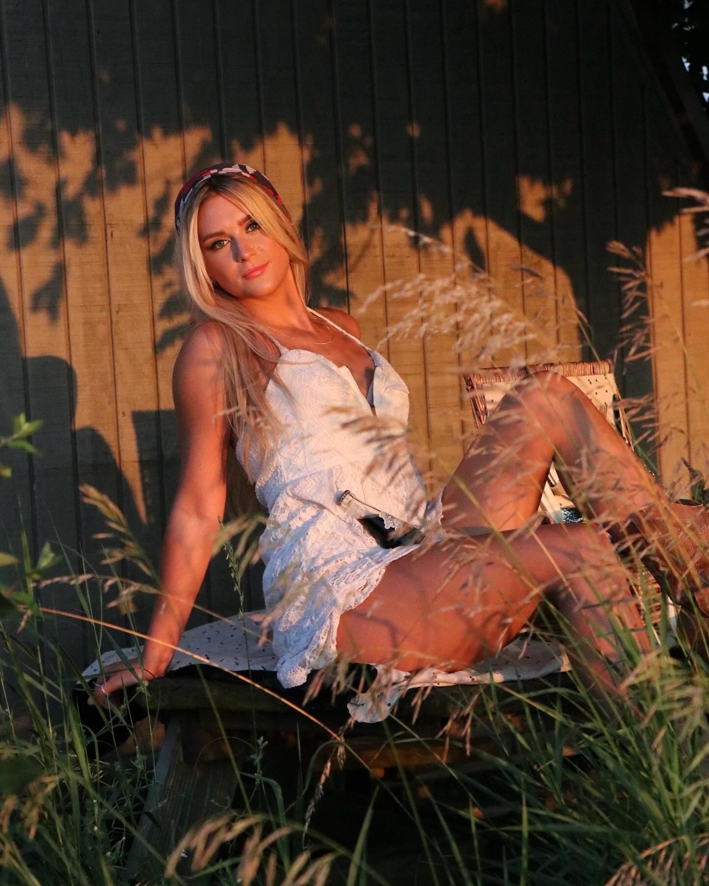 Sunset photography featuring white dress and natural grasses with dramatic lighting.