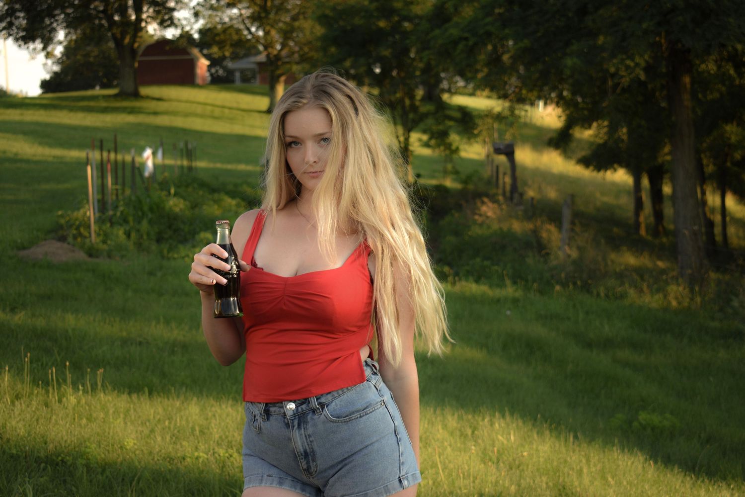 Golden hour photoshoot in grassy field with trees and natural lighting.