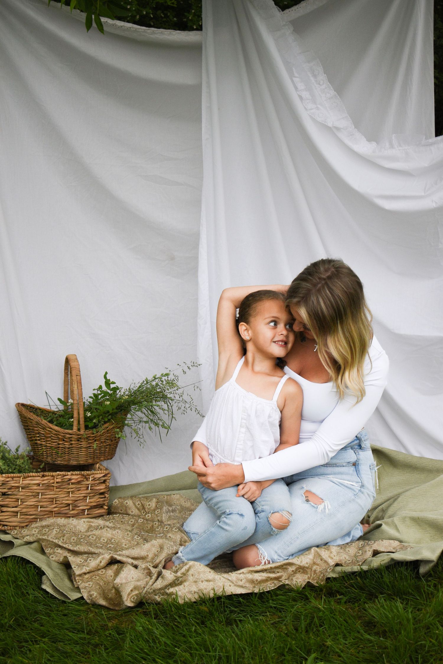 Loving interaction captured on blanket with white backdrop and wicker basket.