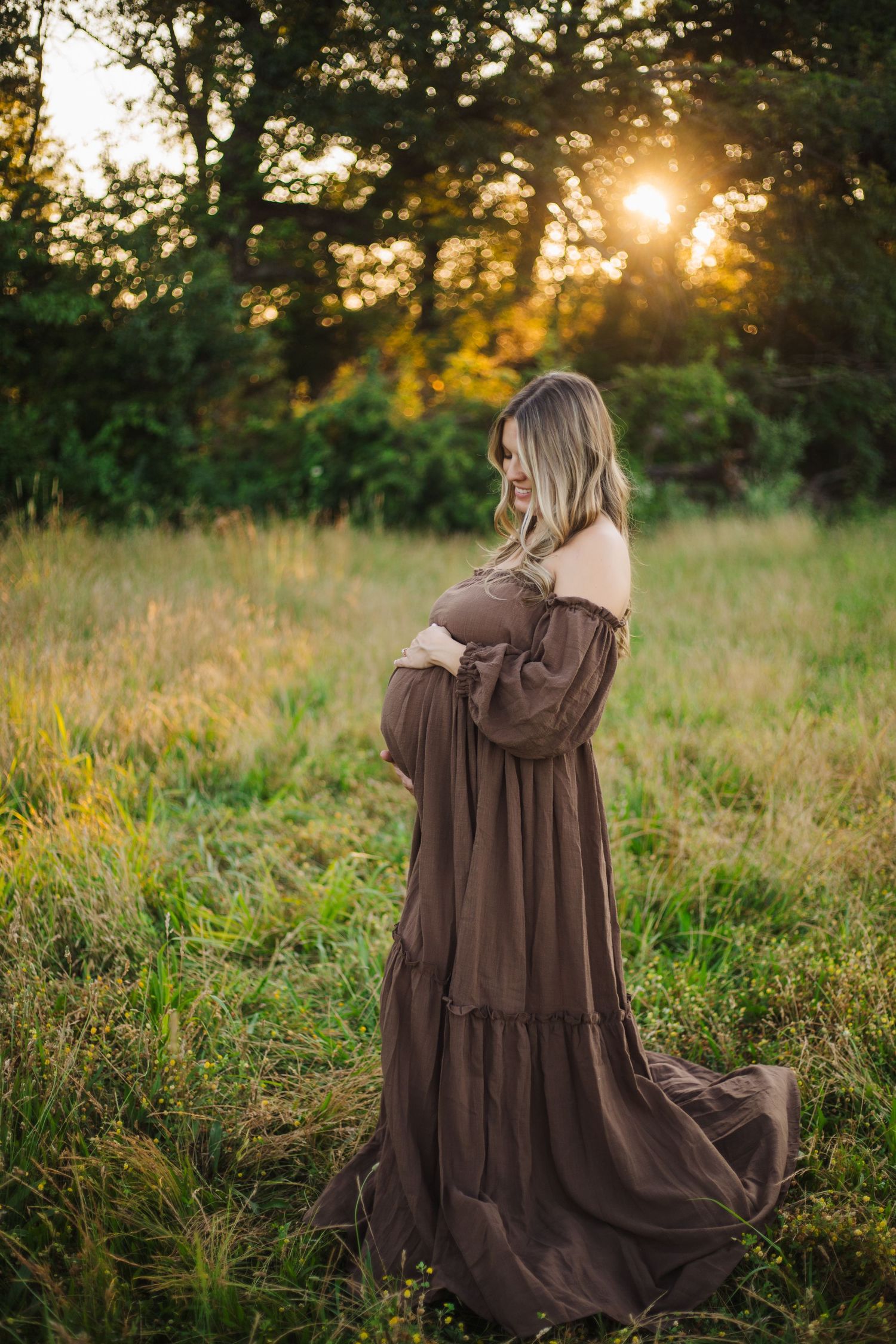 Brown tiered maxi dress photographed in outdoor field during golden hour sunset.