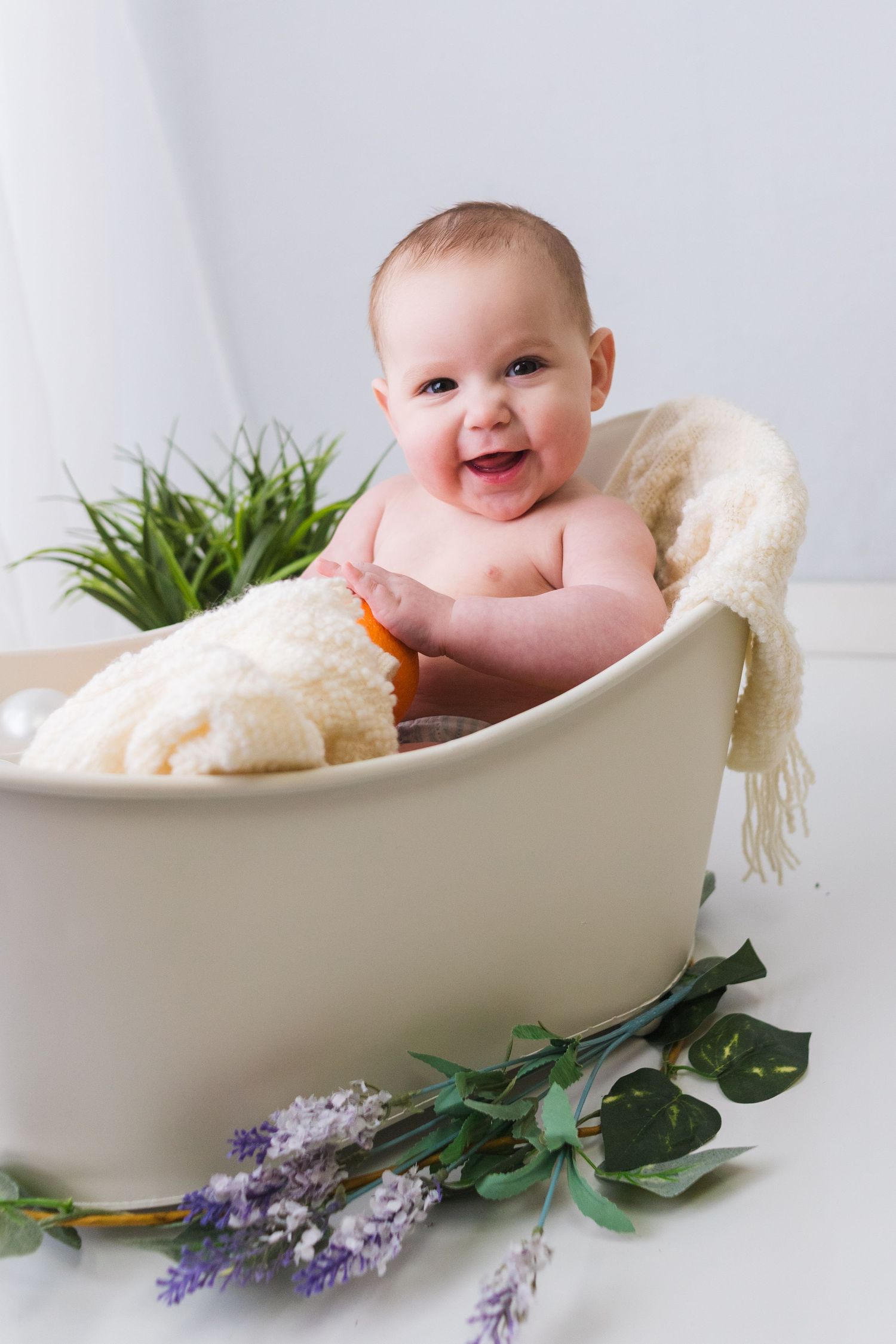 Bath photography scene with cozy blanket, rubber duck, and lavender sprigs.
