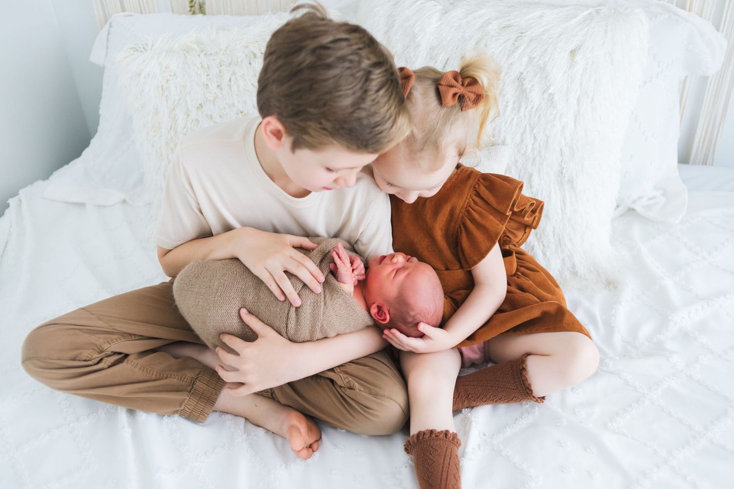 Toddler sibling holding baby brother – gentle family moment captured at Share 417 by Fairchild Photo Co