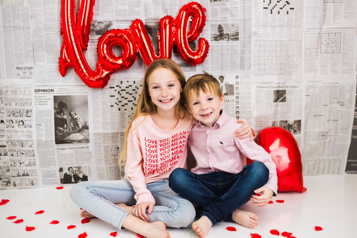 Valentine's Day photo setup with red love balloon and newspaper backdrop.