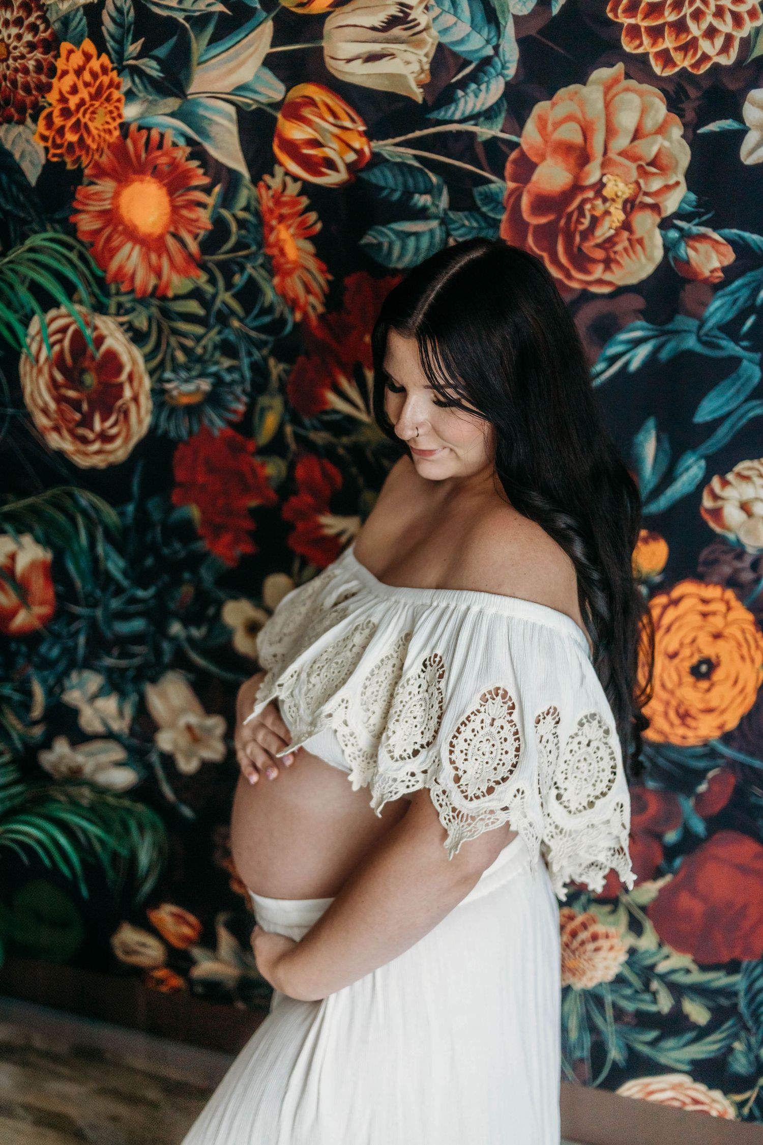 Maternity portrait indoors with floral wallpaper – Springfield MO motherhood photography by Fairchild Photo Co