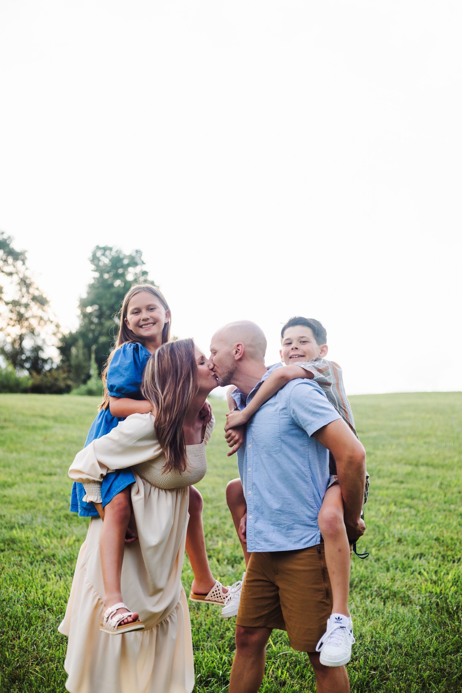 Family playing at sunset in Springfield MO field – natural, candid portraits by Fairchild Photo Co family photographer