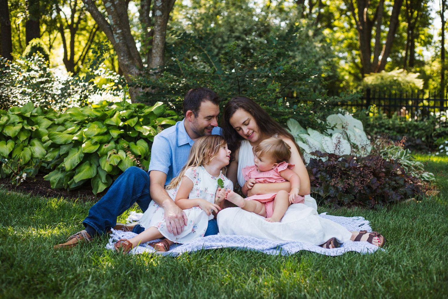 natural family photography with parents and kids laughing in grassy meadow 417 area