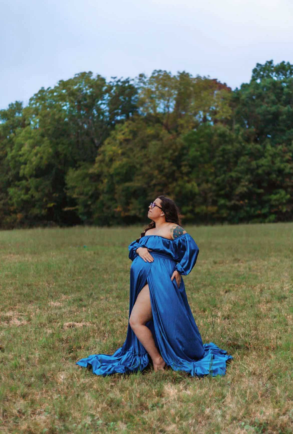 Artistic outdoor photo series of a person in a flowing blue dress sitting on grass in a pastoral setting.