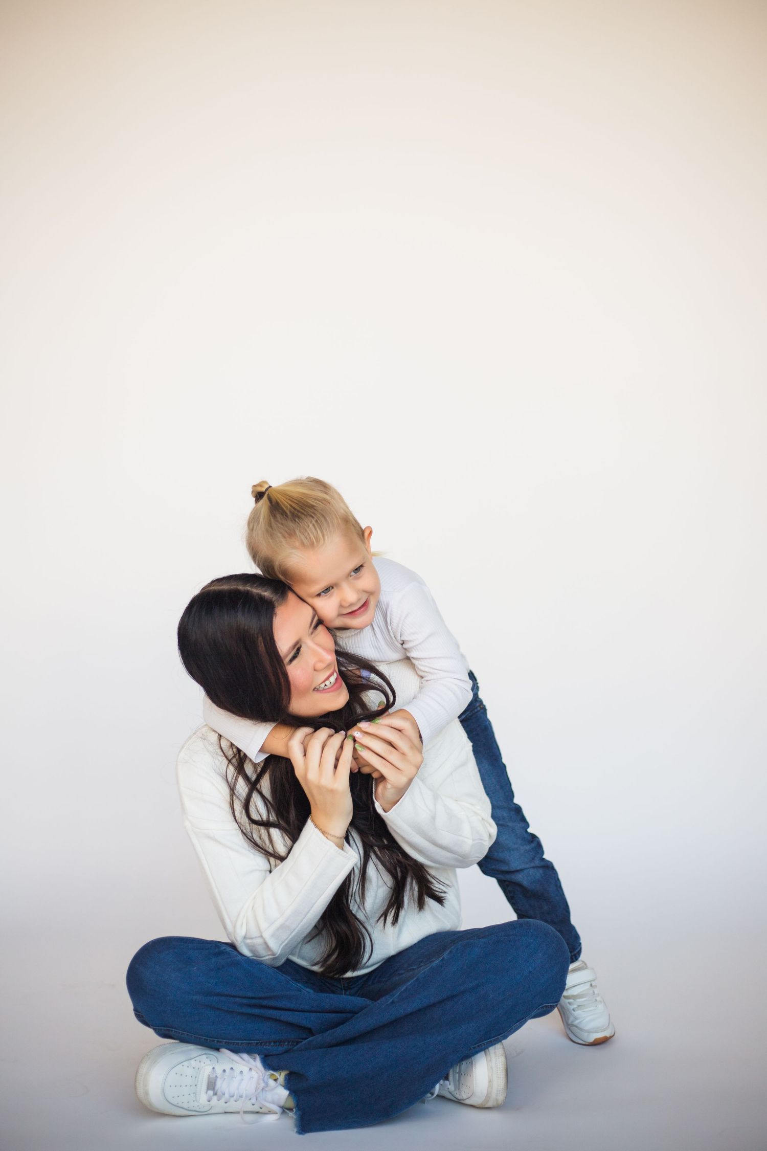 A playful sequence shows someone in a white sweater and blue jeans stretching and posing on a light background.