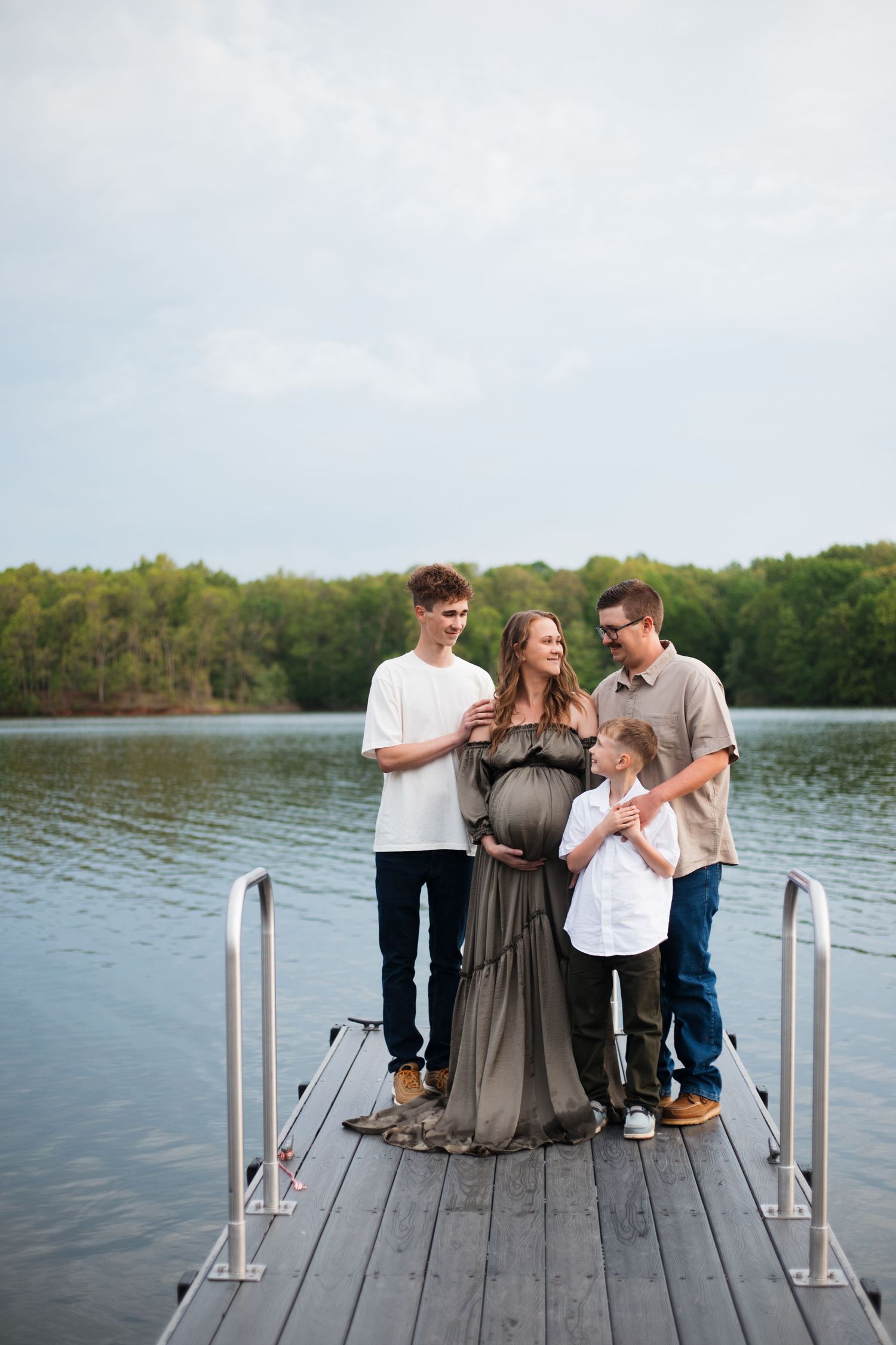 Couple sharing intimate moments on wooden dock by serene lake.