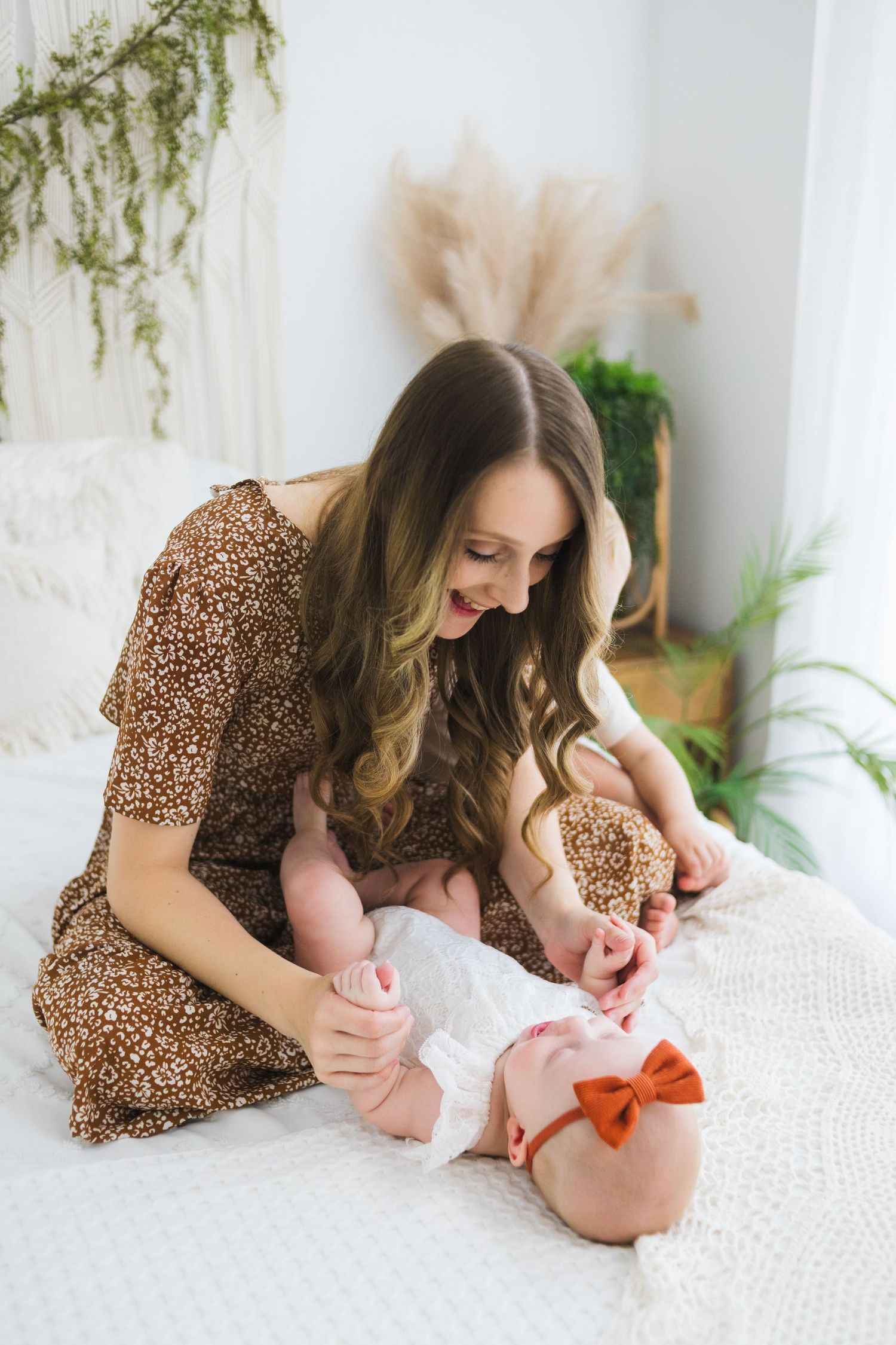 Newborn with parent on white bedding – Springfield MO lifestyle session with greenery by Fairchild Photo Co