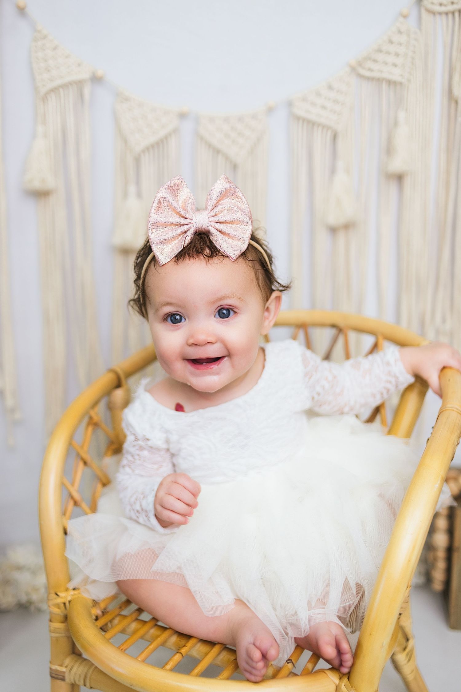 White lace dress and rattan chair setup with macrame wall hanging backdrop.