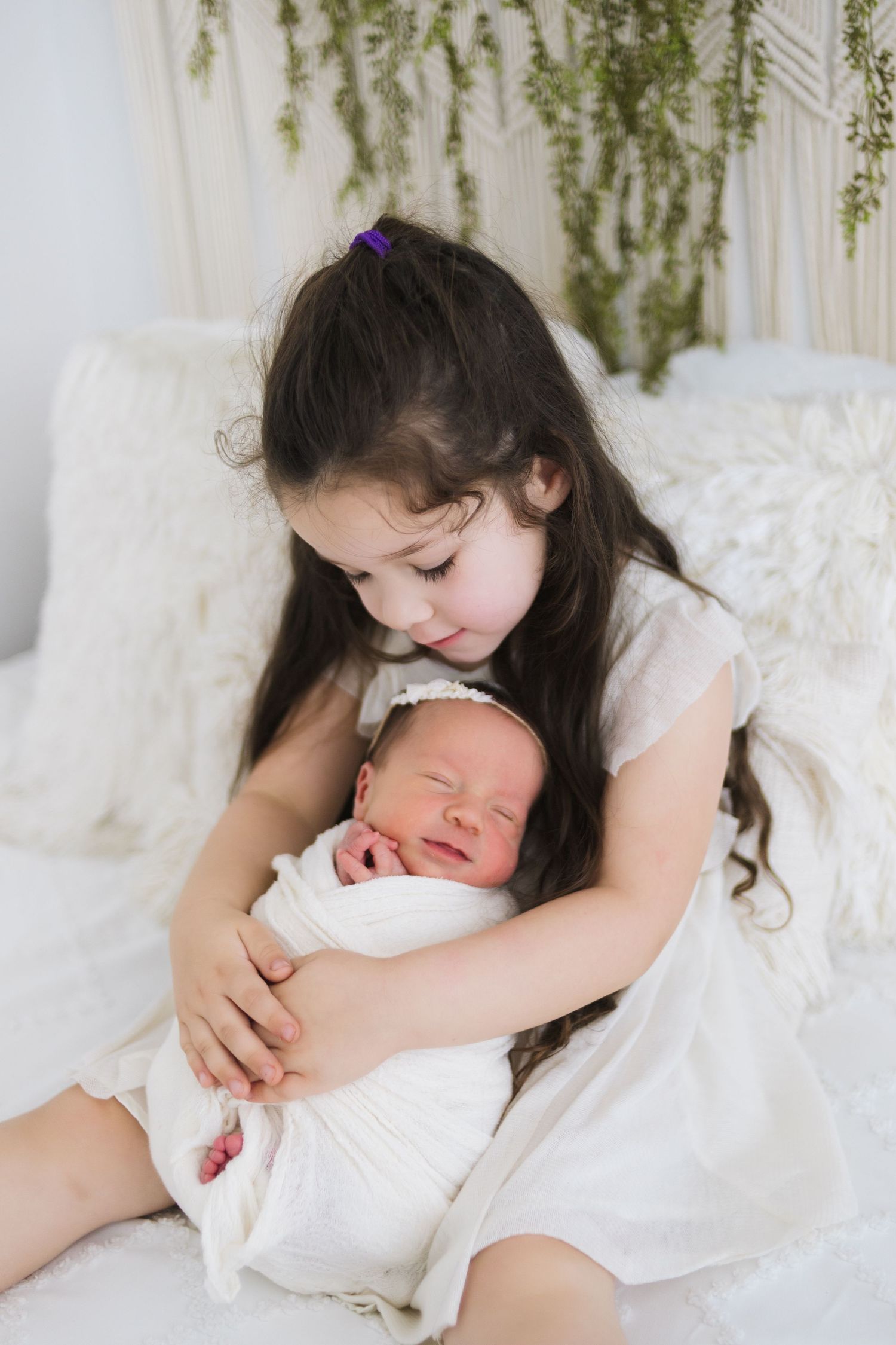 Sibling newborn photo Springfield MO – big sister holding baby sister during studio lifestyle session