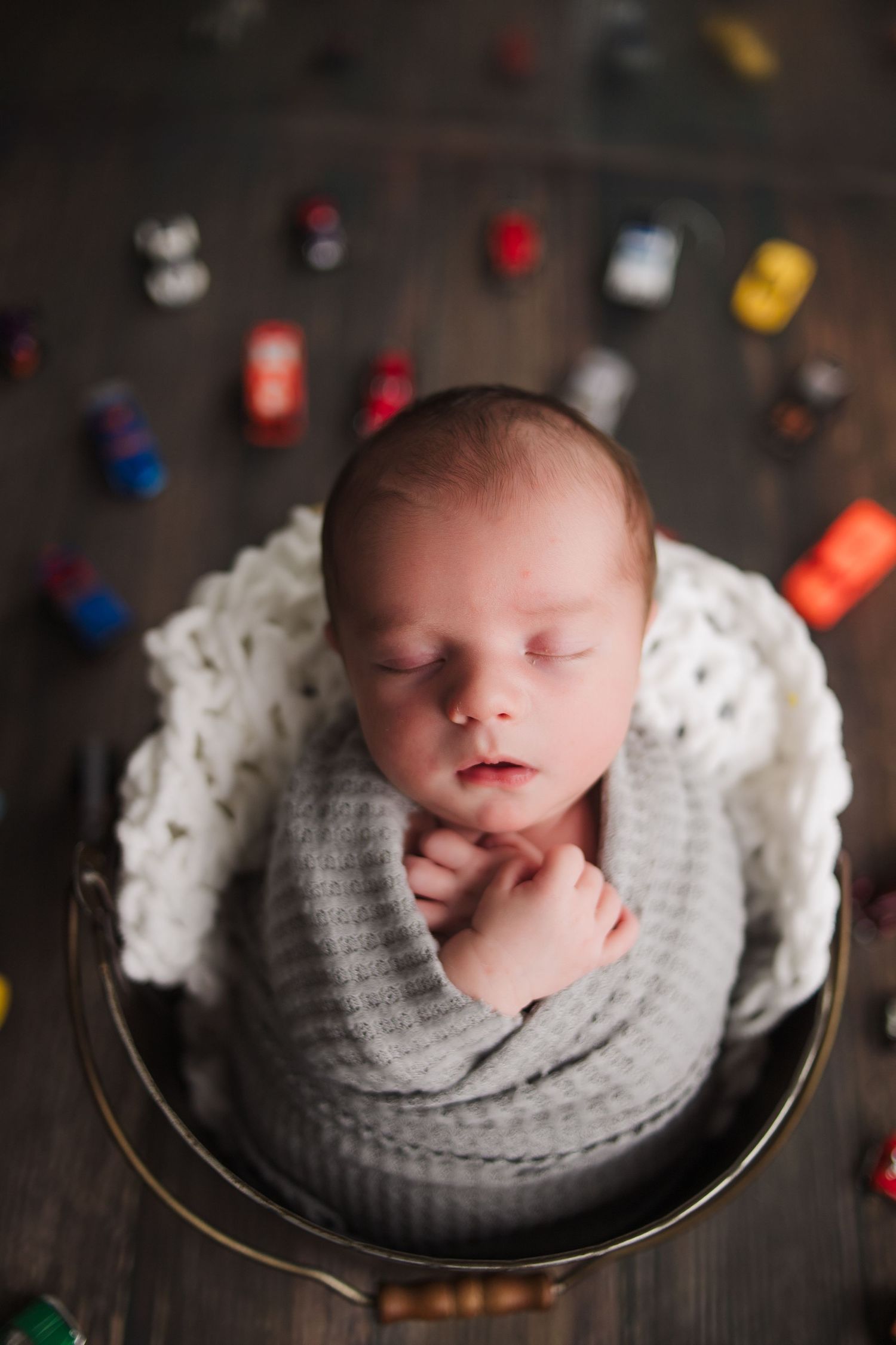 Newborn peacefully resting in a cozy studio basket, photographed by Fairchild Photo Co., Springfield newborn photographer, 417 area.