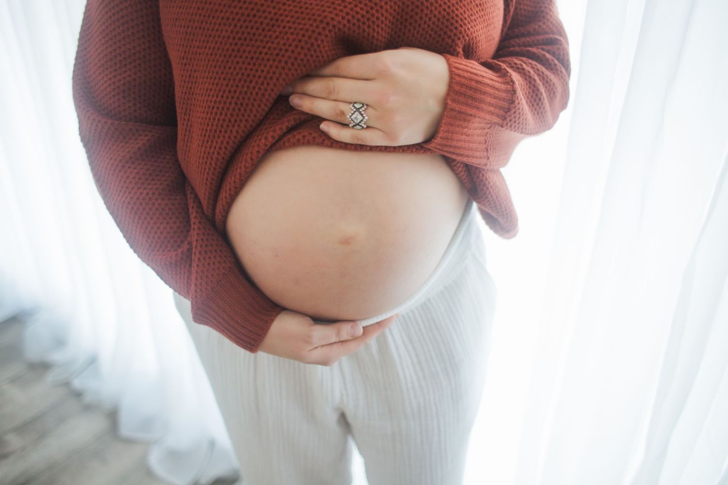A series of close-up photos showing a woman's growing baby bump throughout pregnancy stages.
