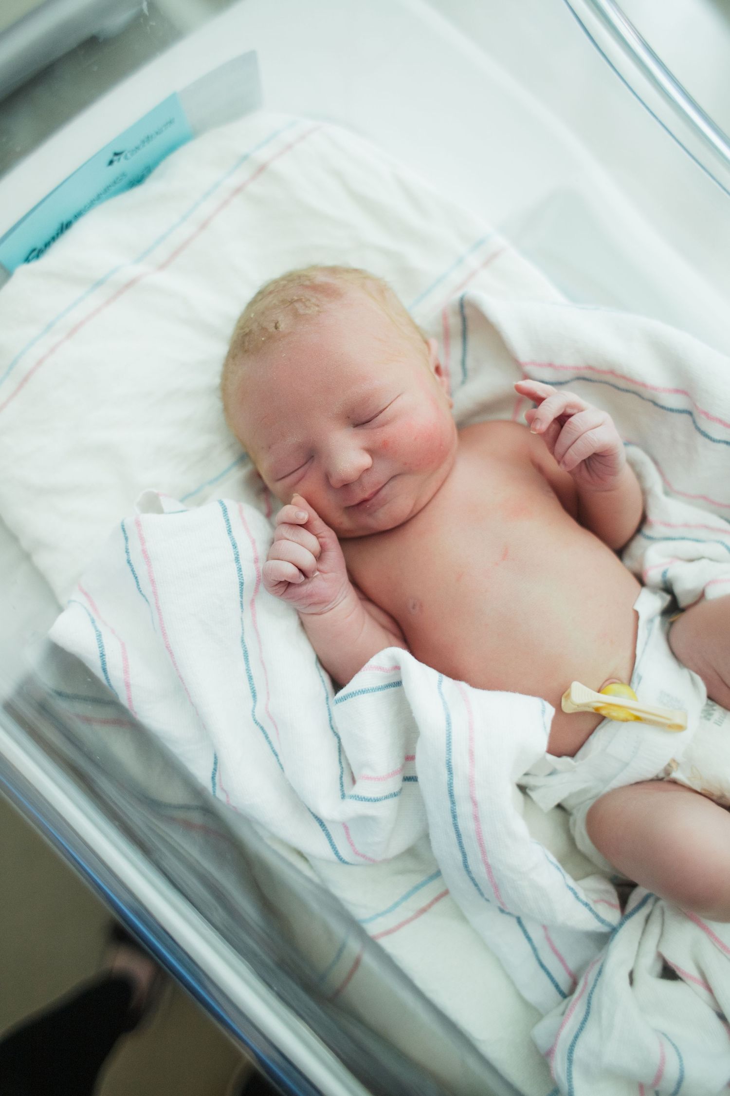 newborn baby sleeping in hospital bassinet wrapped in striped blanket Fresh 48 Springfield MO