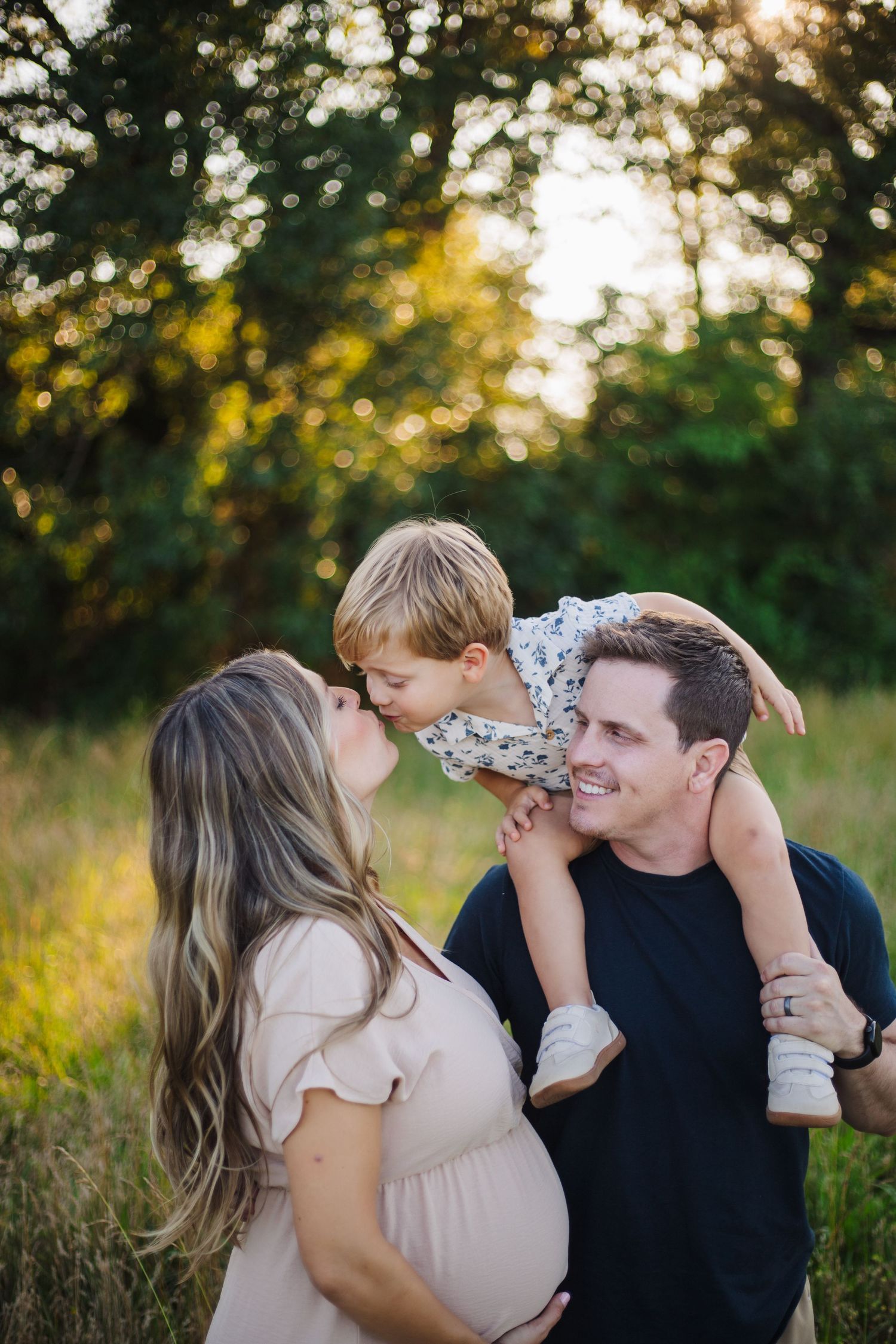 Family moment captured during sunset in tall grass field.