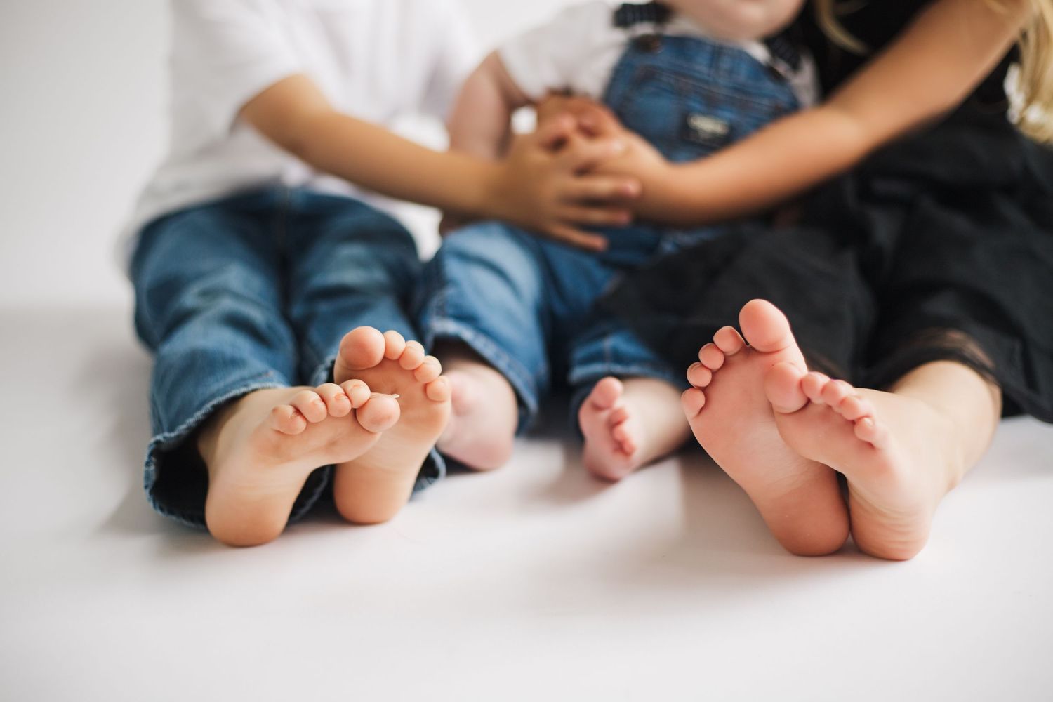 Close-up of bare feet lined up together on white background showing family connection.