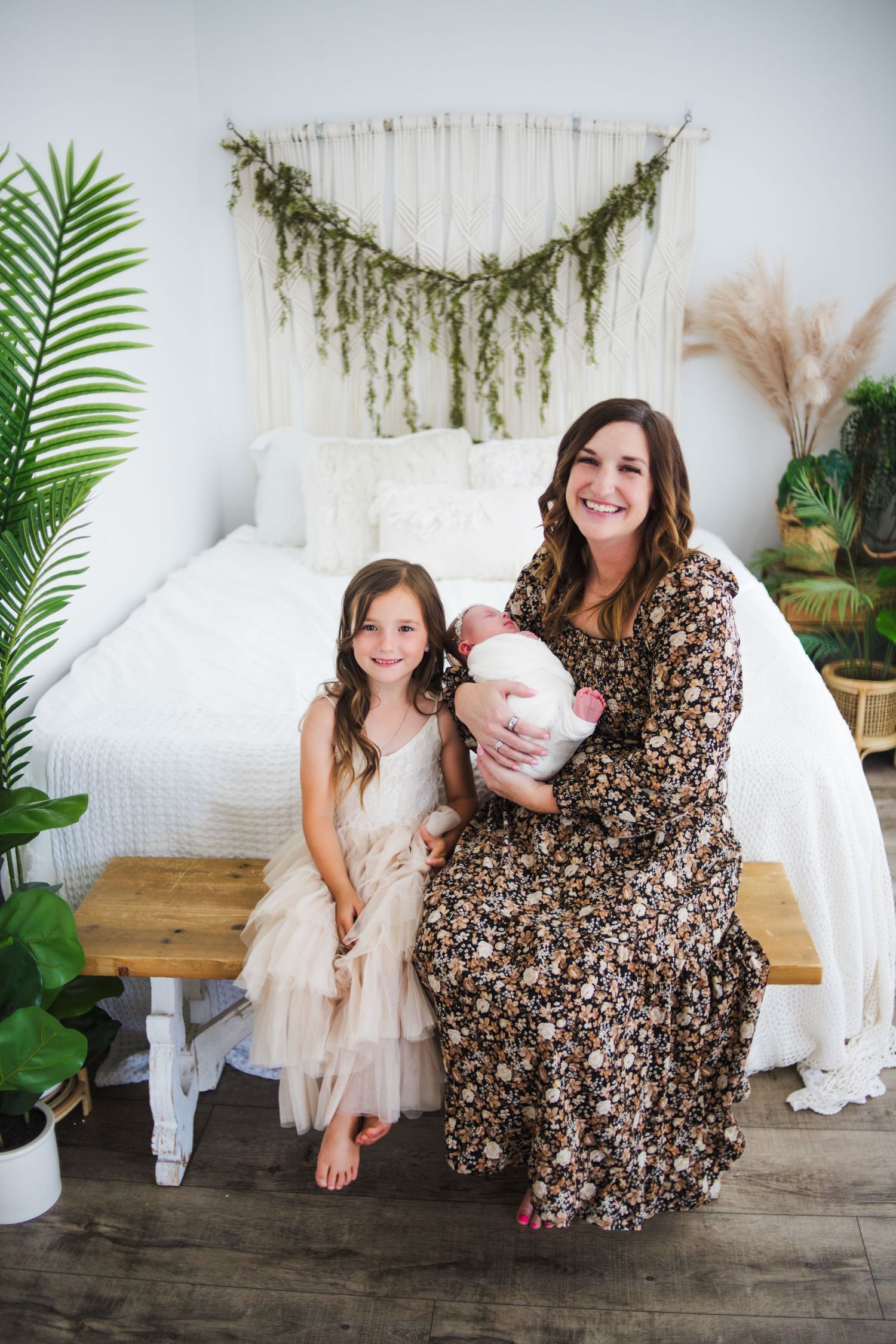 Boho-styled bedroom photo shoot with greenery garland and pampas grass decor.