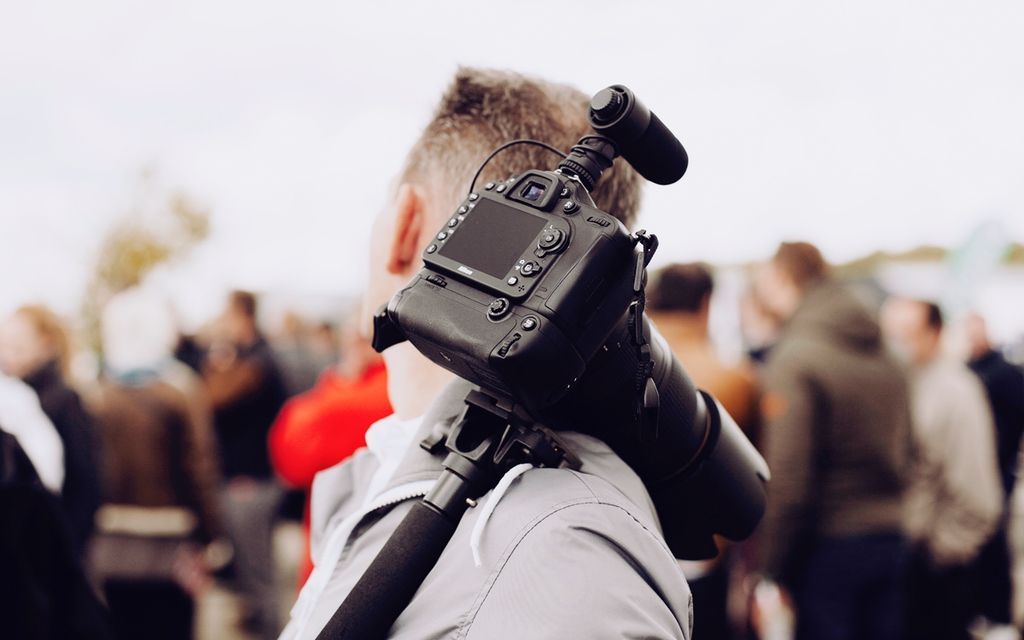 DSLR camera mounted on professional equipment photographing a crowd at an event.