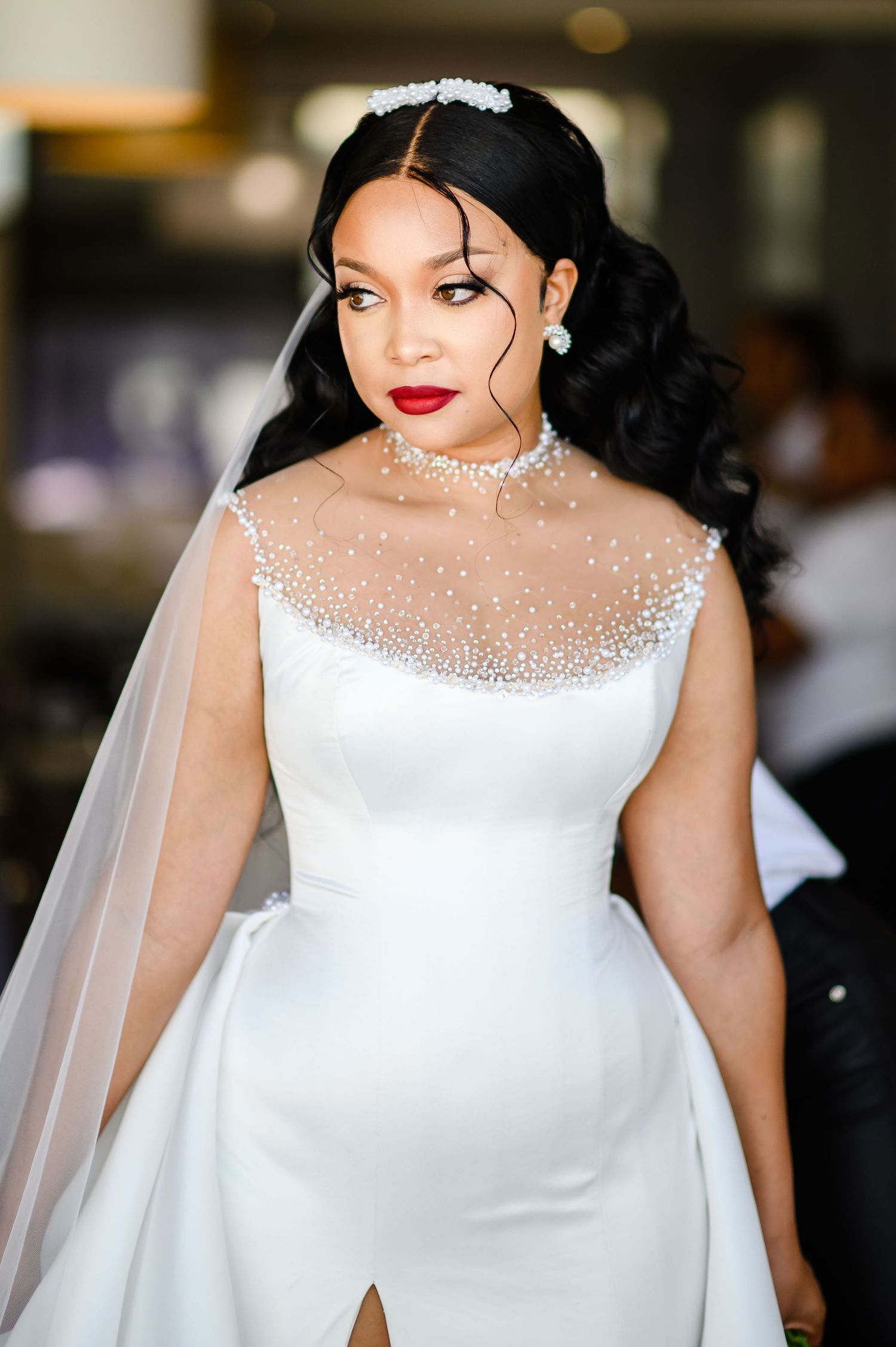 Stunning bridal portrait featuring an elegant white wedding gown with sheer illusion neckline adorned with sparkling crystals.