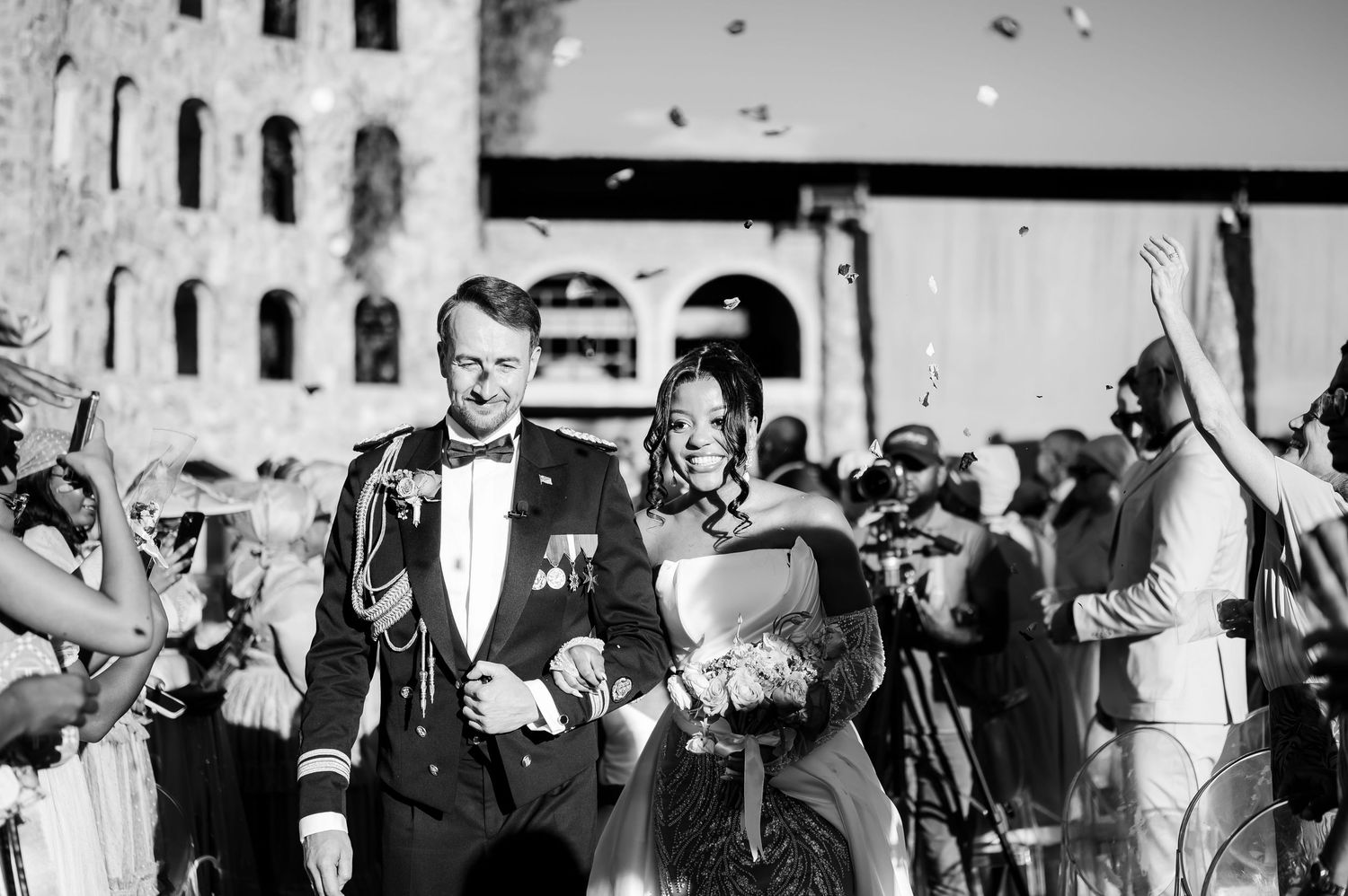 A black and white photo collage of a wedding party dancing and celebrating at a reception.