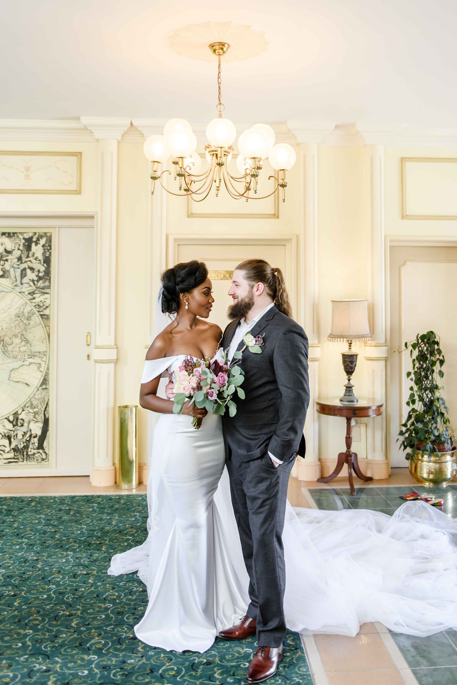 Wedding couple sharing an intimate moment in an elegant room with chandelier and ornate details in Swakopmund