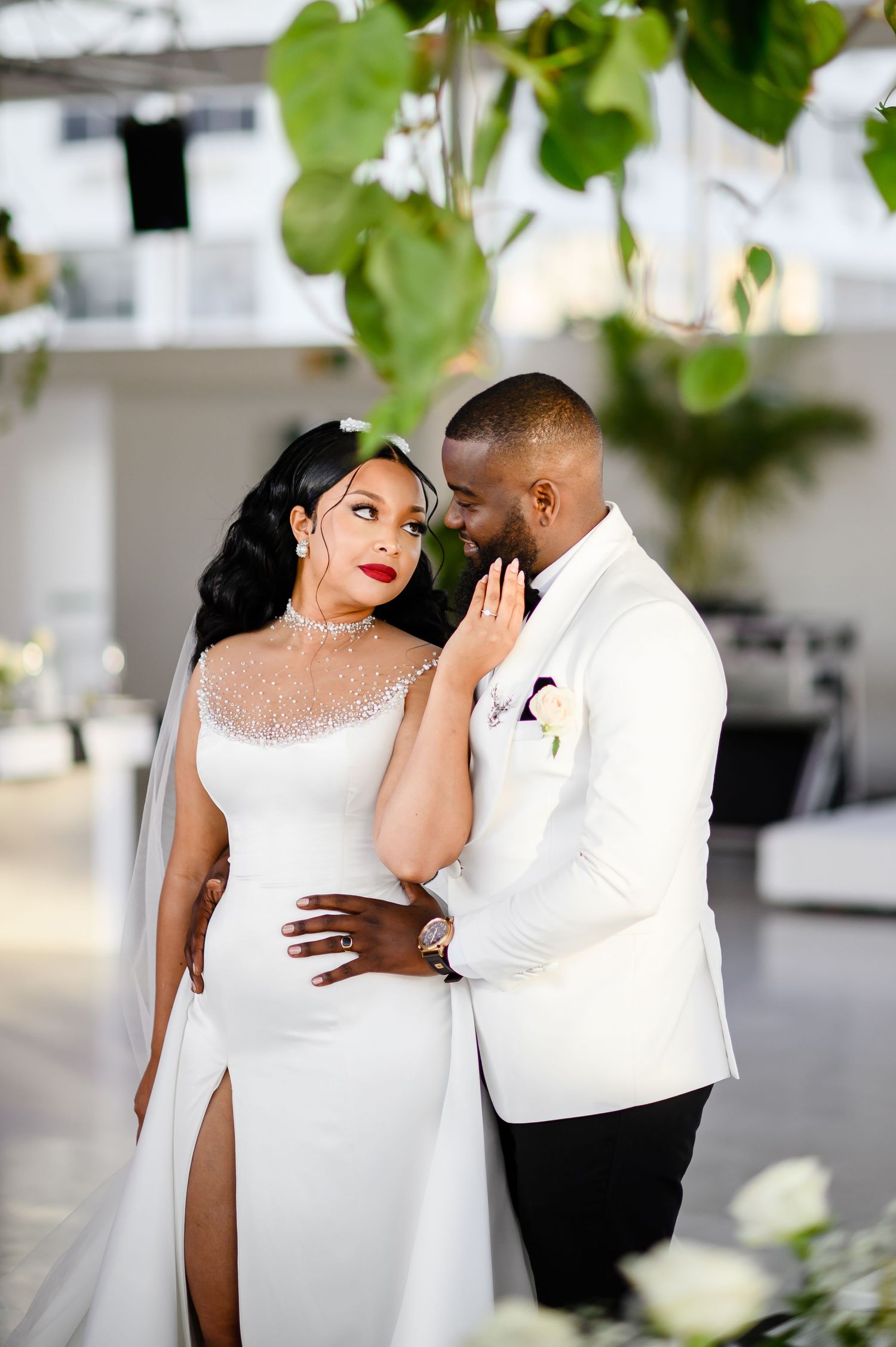 Elegant wedding couple in white attire sharing intimate moment during outdoor photo session in Cape Town