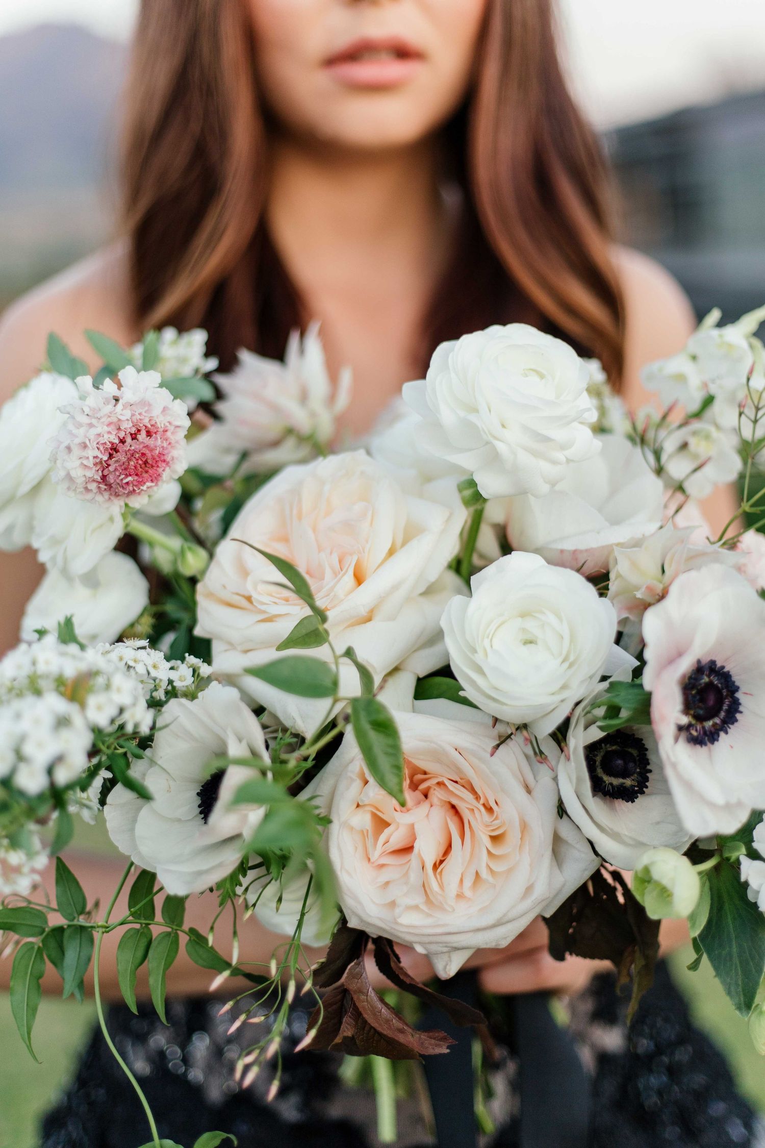 Close-up of a lush bridal bouquet featuring white roses, anemones, and delicate greenery in Cape Town