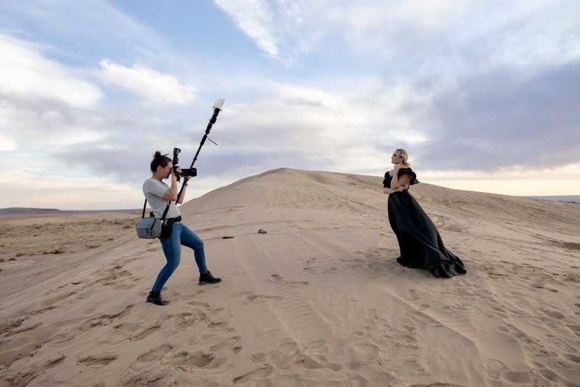 Professional photographers capturing stunning desert landscape photos during golden hour lighting.