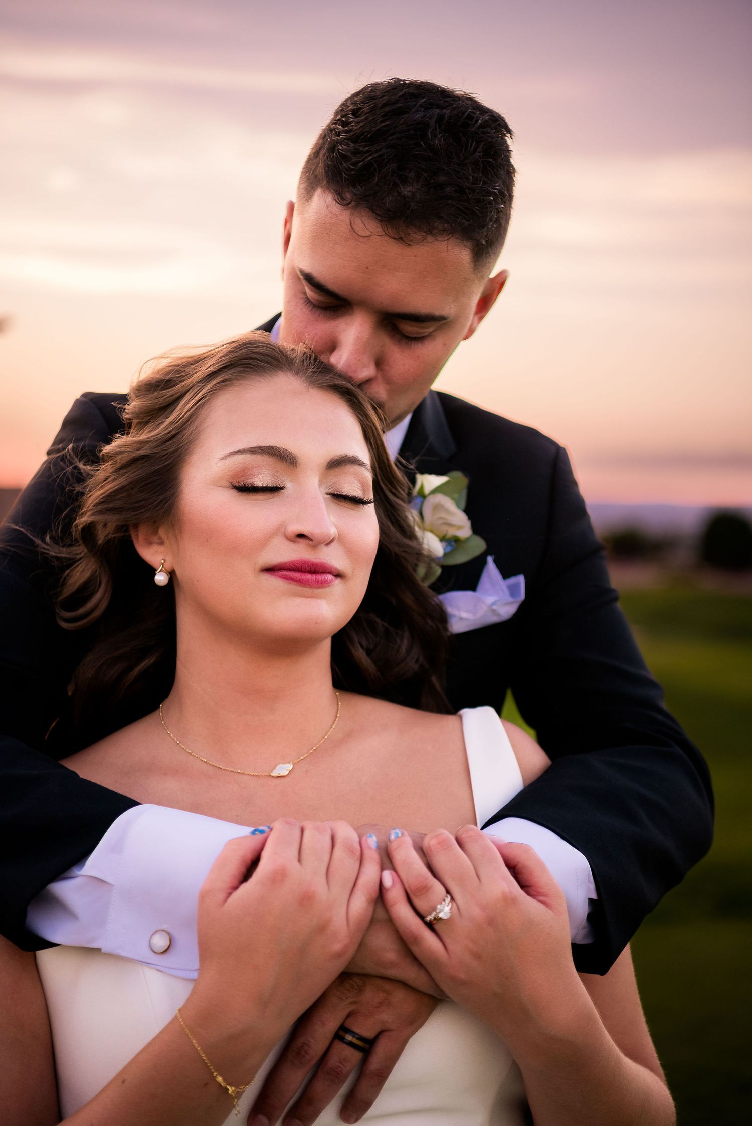 A sunset wedding photo on a golf course with the Sandia Mountains glowing pink in the background  at the Sandia Event Center in Albuquerque.