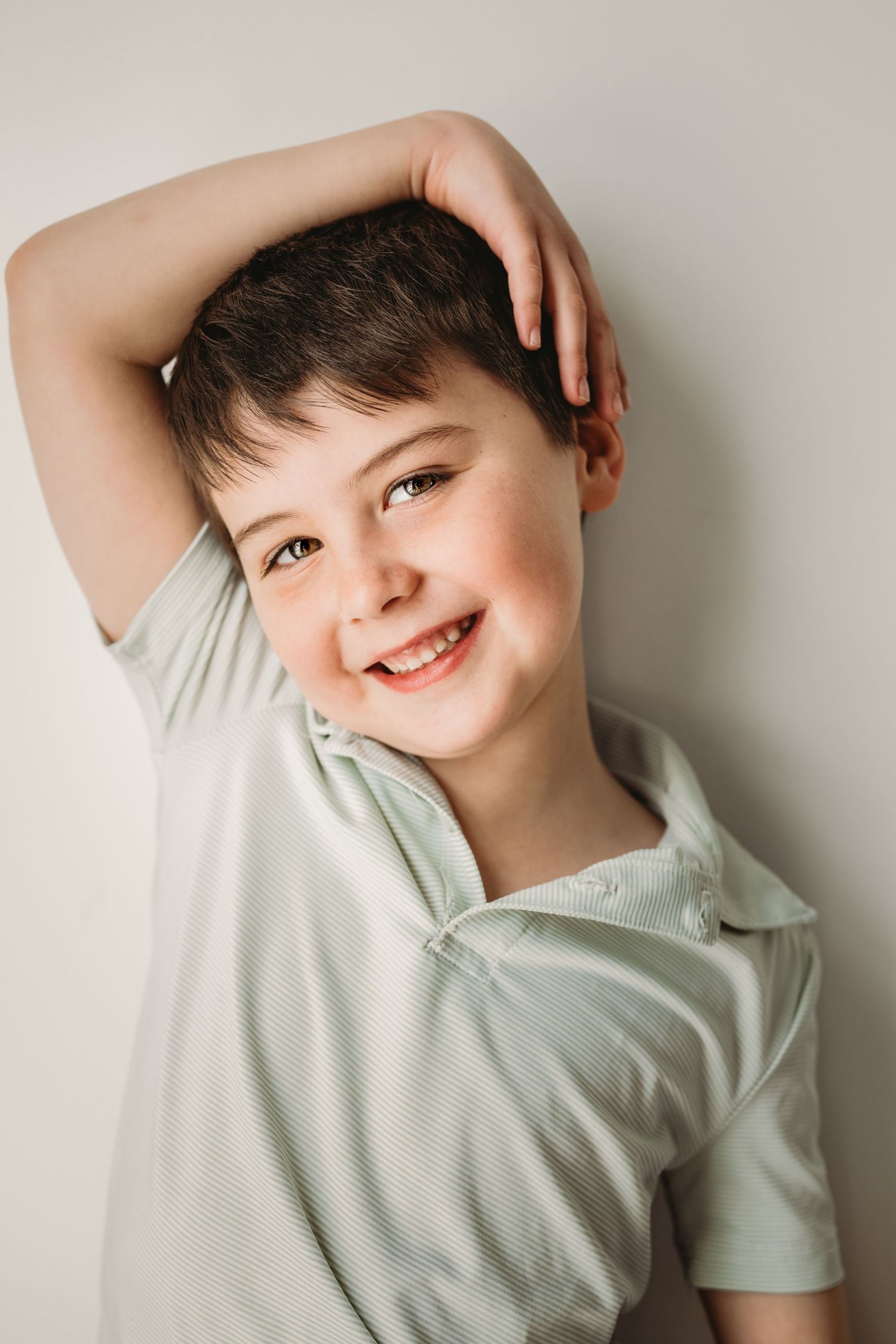 A series of four playful portrait photos showing joyful expressions against a light colored wall.