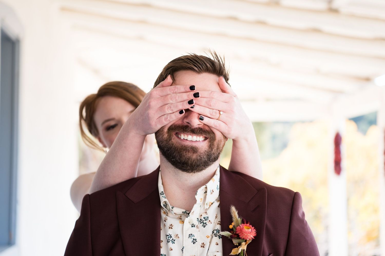 Wedding party members laugh together during a candid moment at a reception.