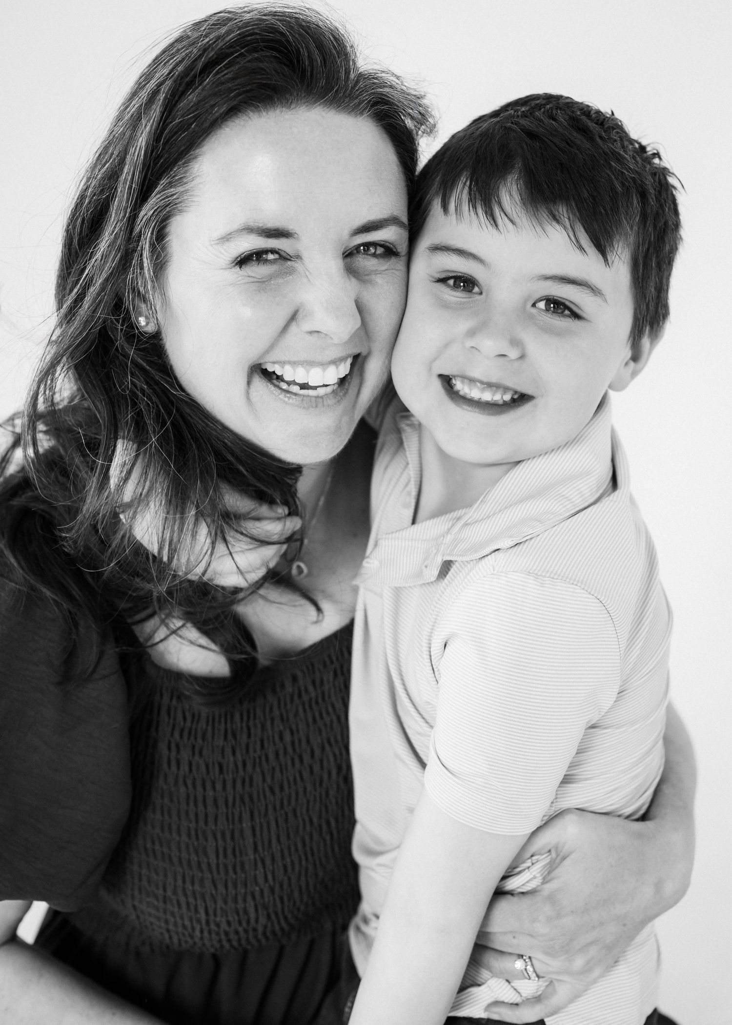 A series of black and white candid photos showing joyful expressions and warm embraces between two people.