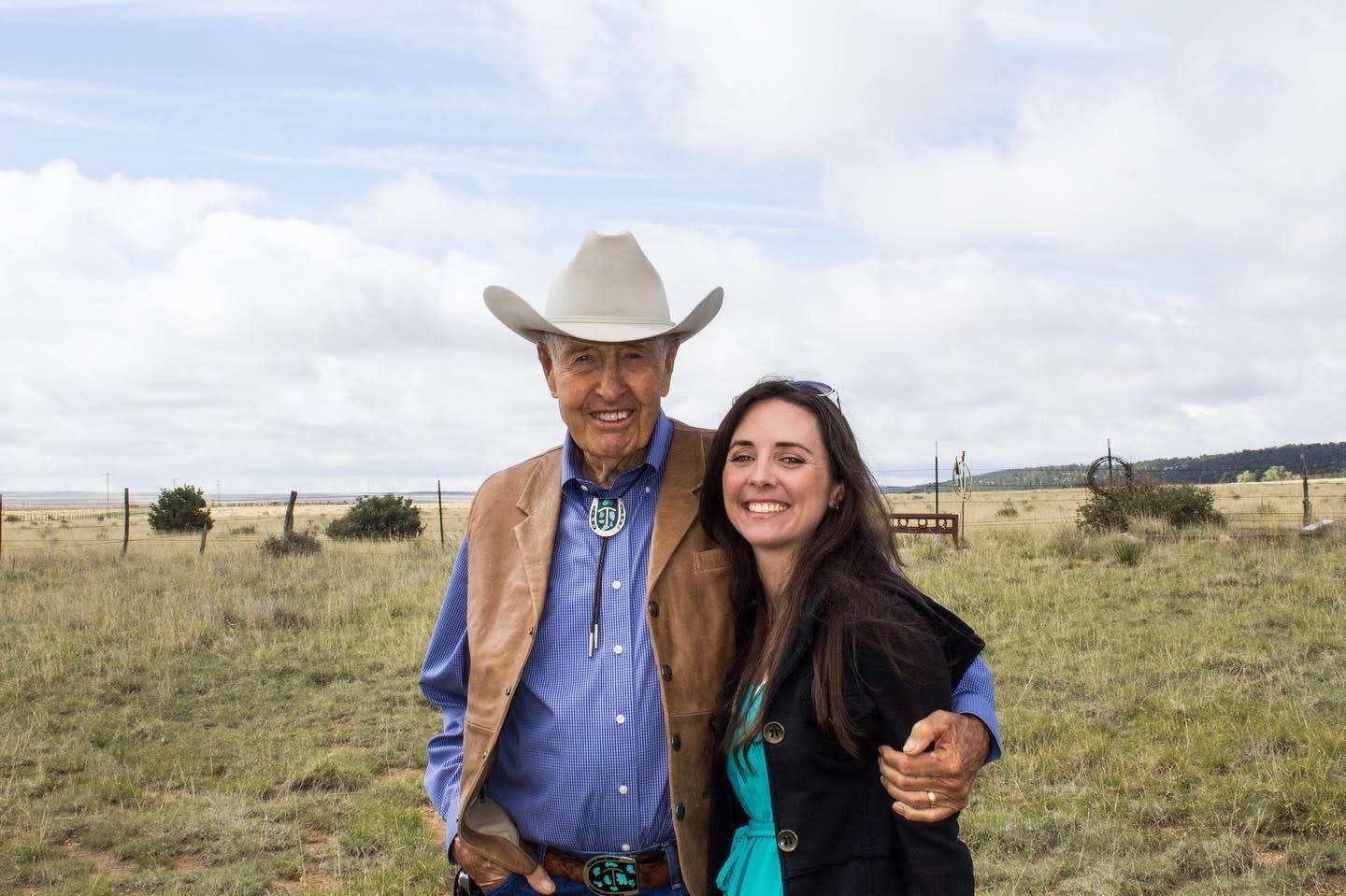 People spending time together on a rural ranch with rolling grasslands and Buffalo in the background.