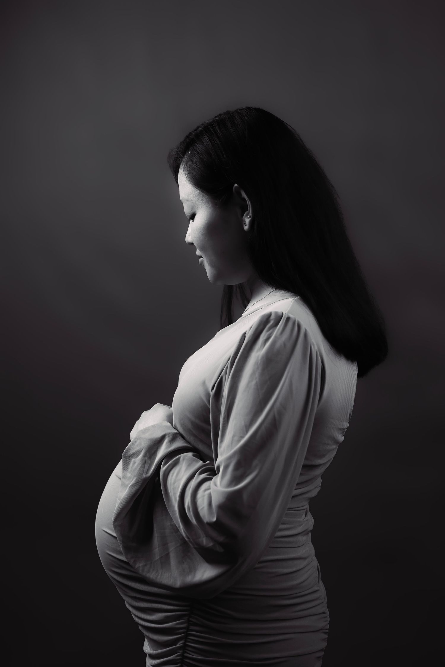 Artistic black and white portrait series showing pregnant woman in side profile poses.