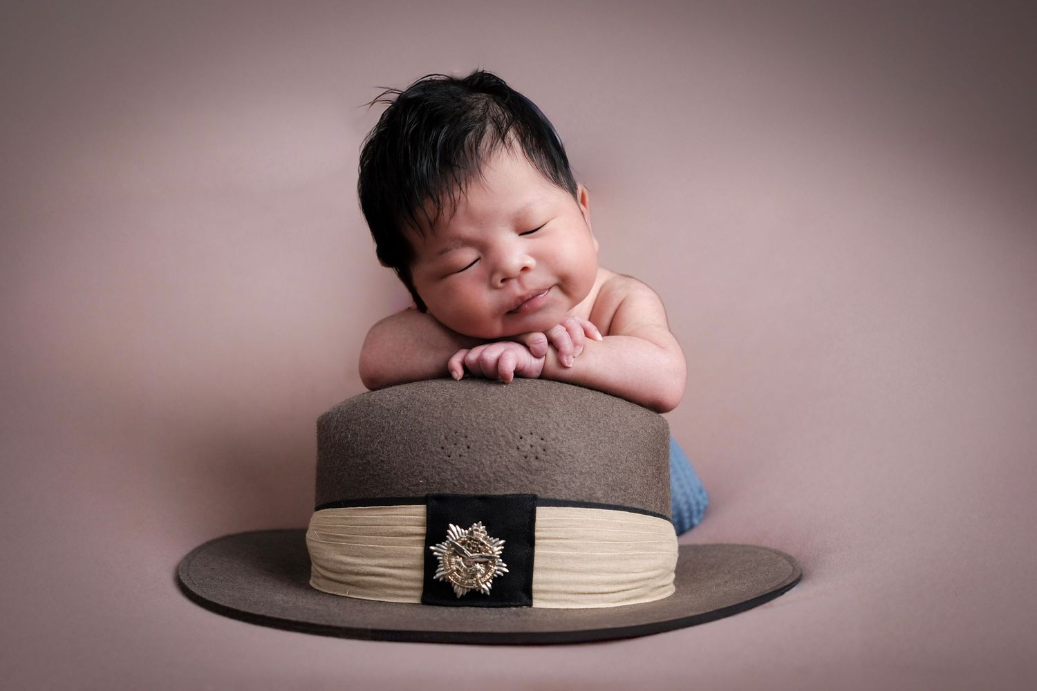 Sweet newborn photography session with soft pink backdrop and gentle poses.