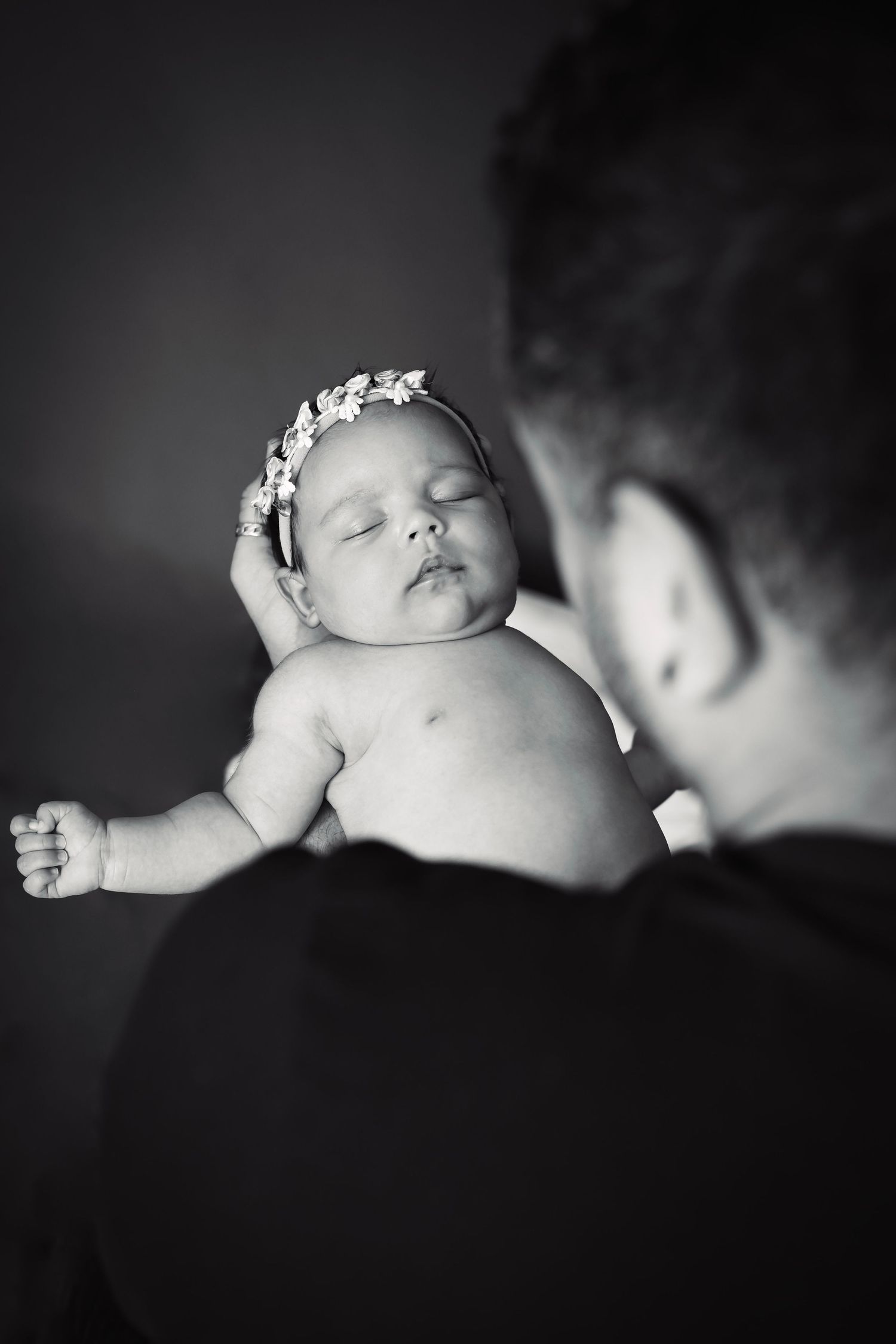 Intimate black and white portrait of sleeping newborn with soft lighting.
