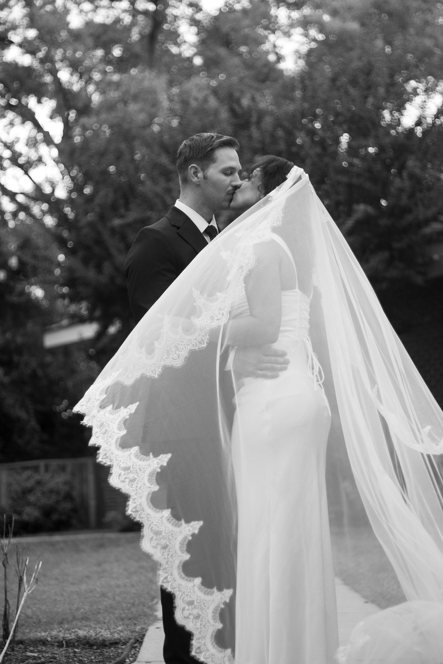 Bride and groom portraits with veil blowing in wind after their small church wedding in Fayetteville, NC.