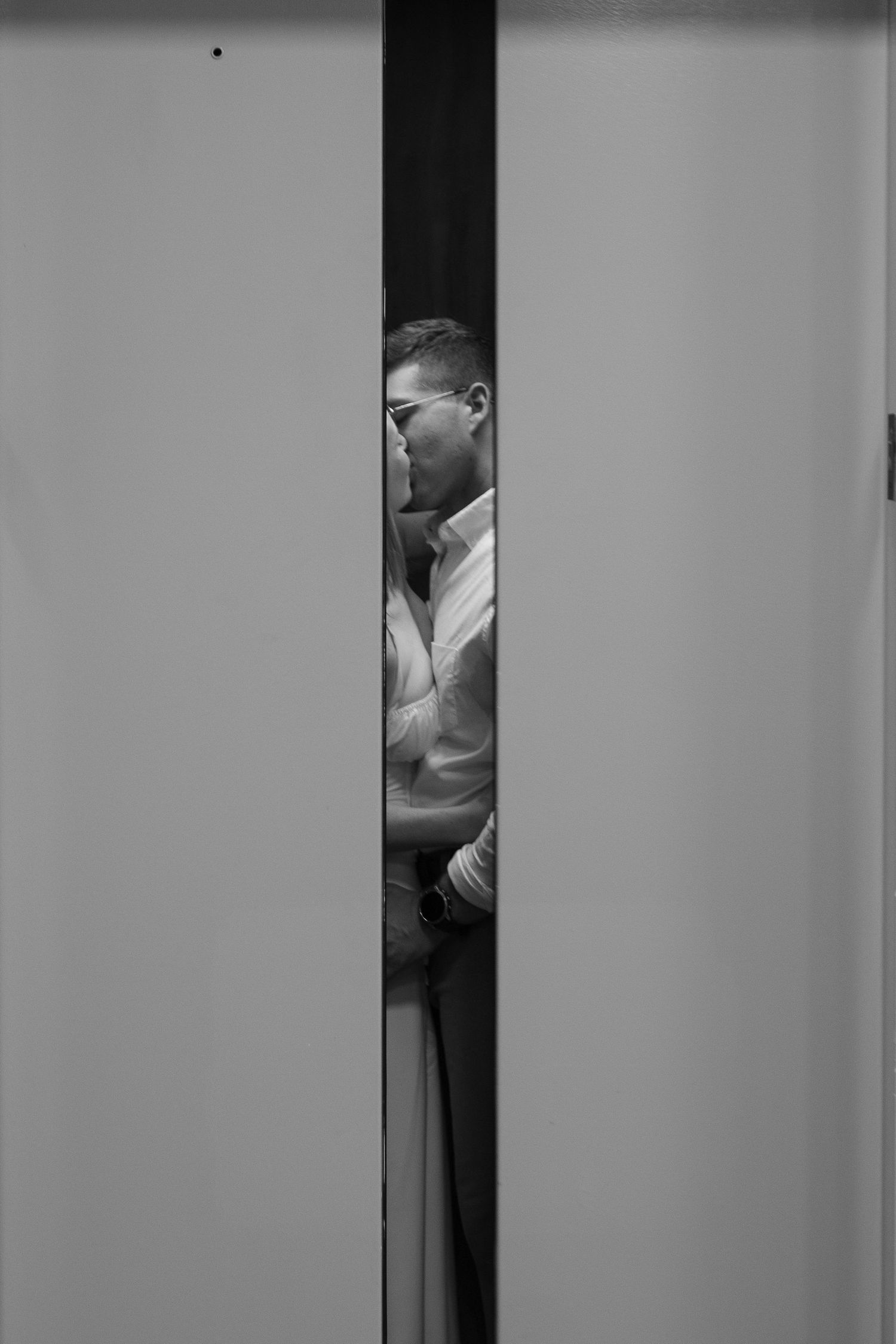 Couple kissing peaking through elevator after their intimate courthouse wedding at Brunswick County Courthouse, NC.