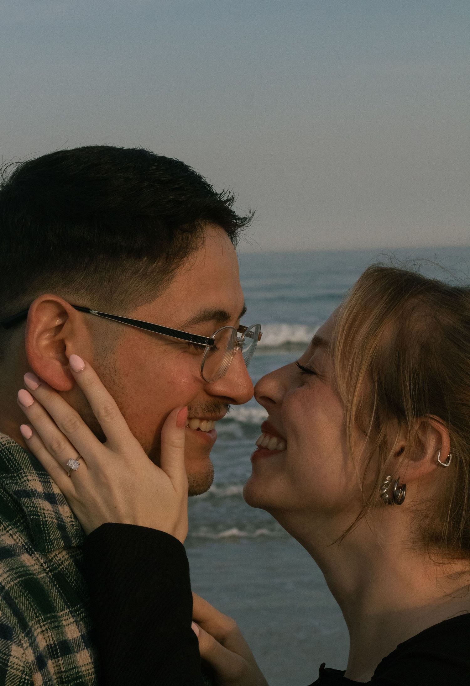 Couple standing together by the water during a natural engagement photography session in Wrightsville Beach, NC.