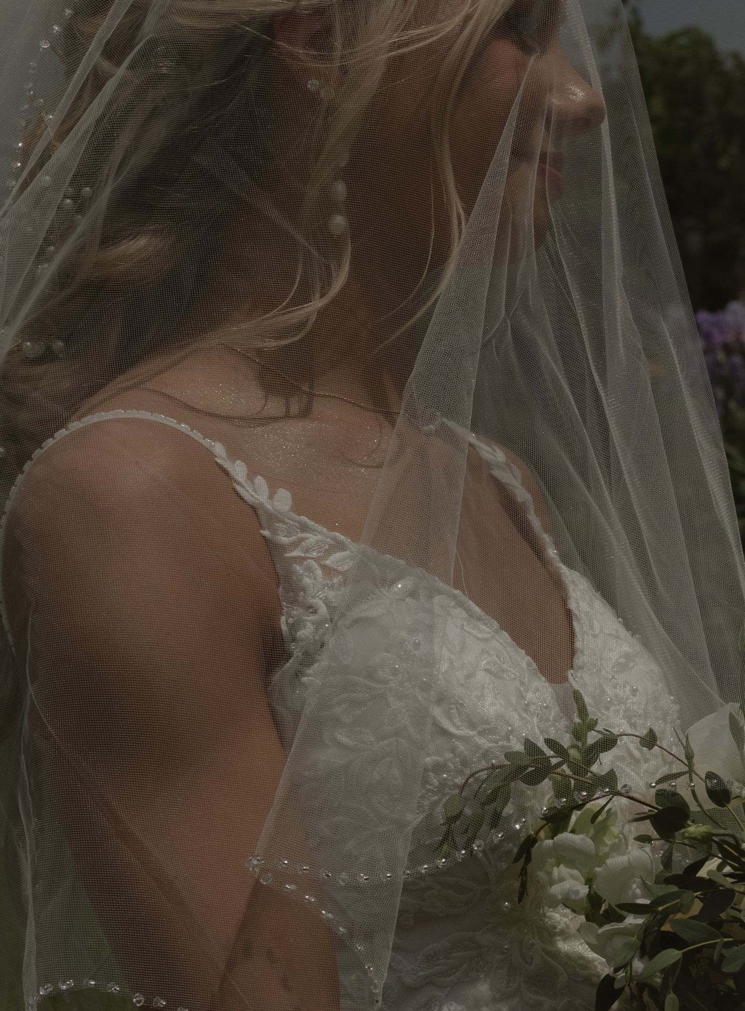 Bride posing under veil for bridal portraits during a Michigan wedding photography session.